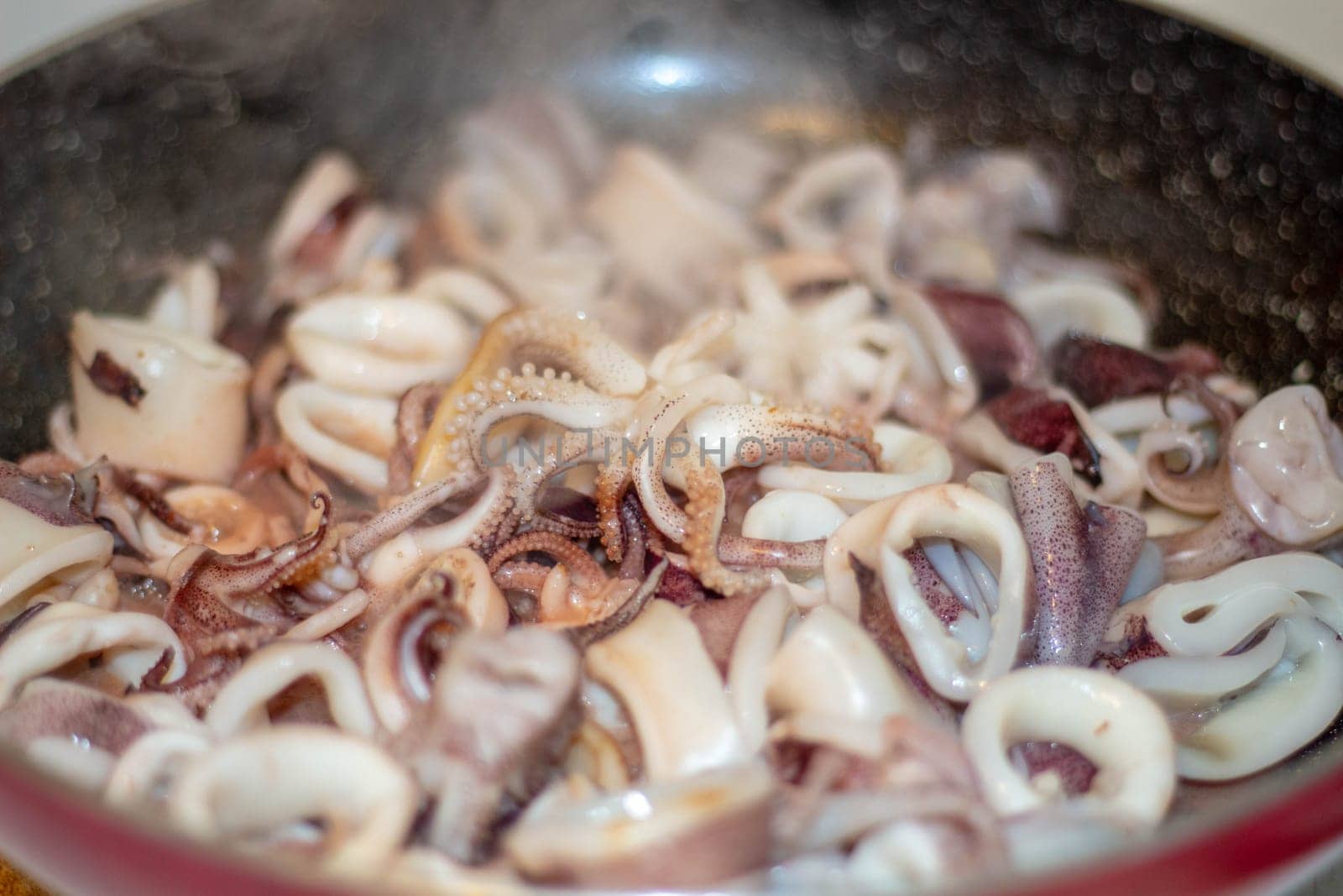 Indulge in the sizzle and aroma of freshly cooked calamari frying in the pan. Experience the culinary artistry and delight of Mediterranean cuisine