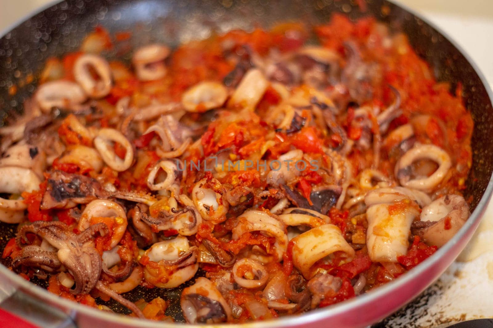 Dive into the essence of Spanish cuisine with succulent calamari simmered in traditional sofrito sauce, ready to elevate your paella to perfection