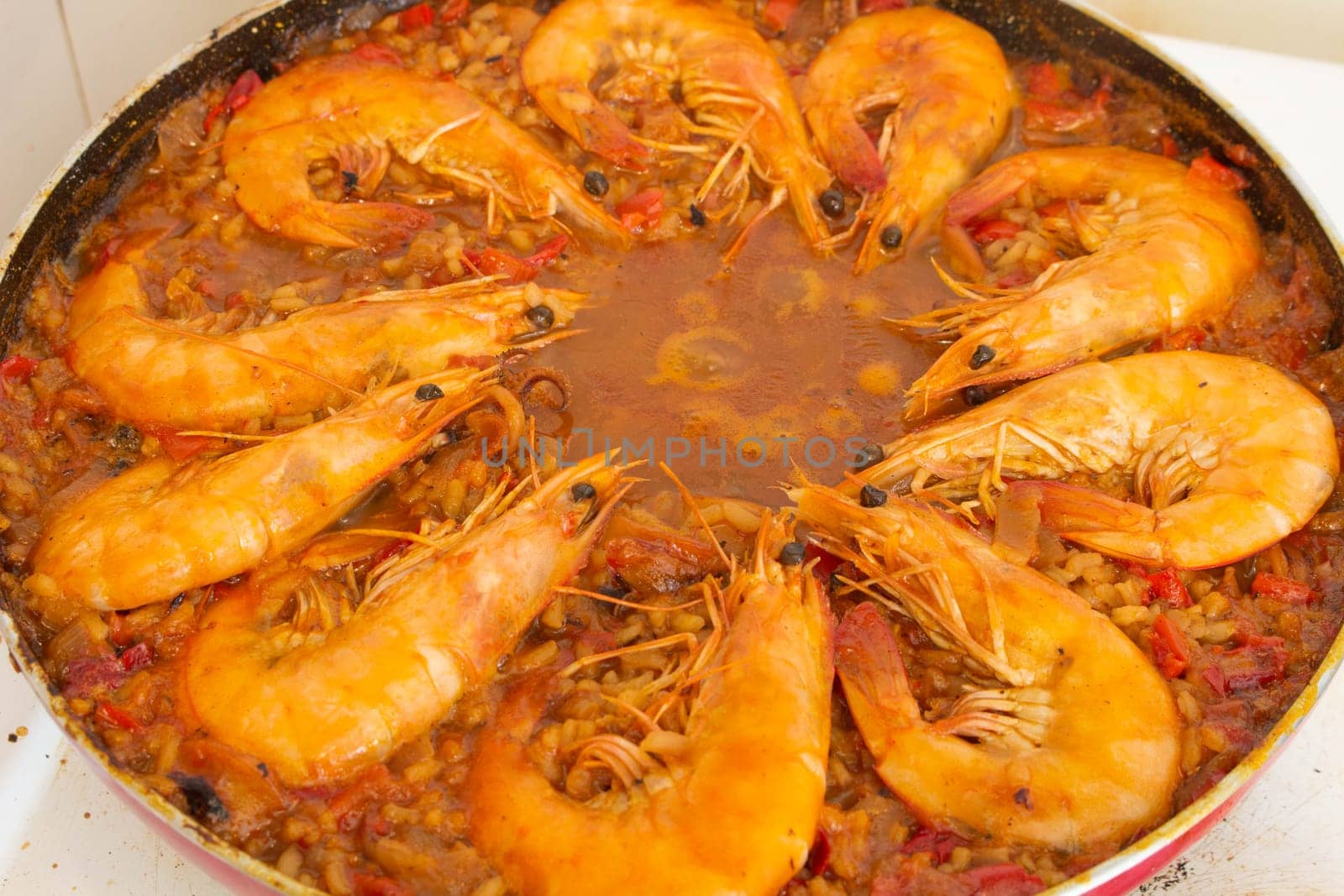 Experience culinary harmony as golden-fried shrimp rejoins the vibrant medley of flavors in the traditional Spanish paella, enriching each bite with savory delight