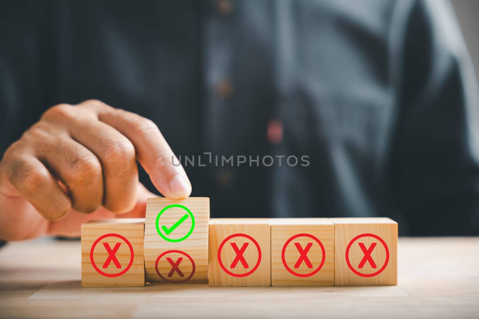 Wooden cube flipped by hand, red cross to correct tick representing project approval concept. Close-up symbolizing choice. Think With Yes Or No Choice.