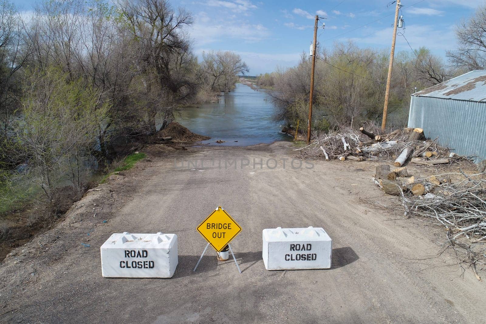 road is closed as the bridge is out due to being submerged under the river with high flood levels