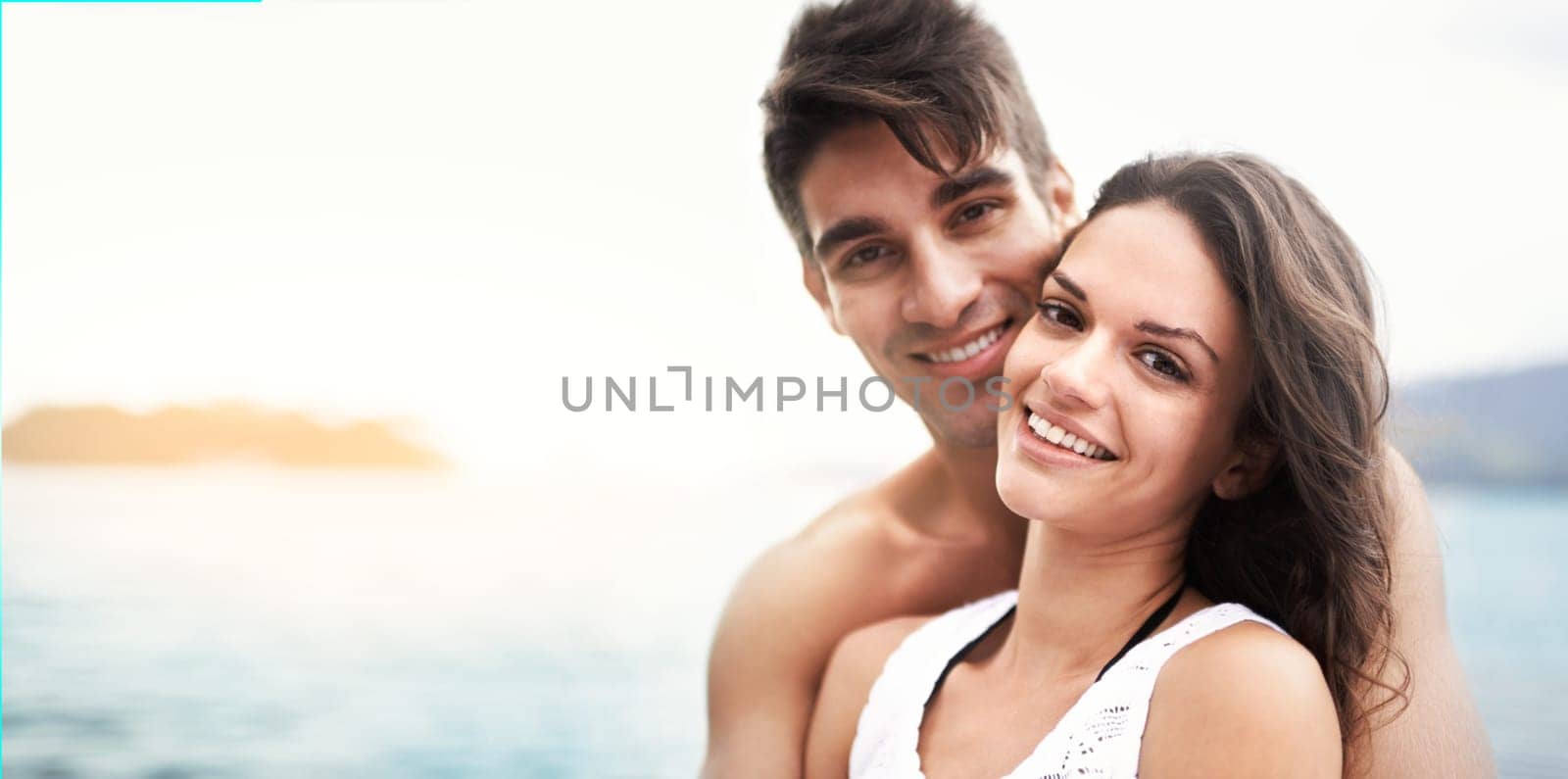 Love, portrait and happy couple at beach with care, security and bonding on vacation together. Nature, summer or young people or fun at sea for travel, holiday or adventure on romantic date in Spain.
