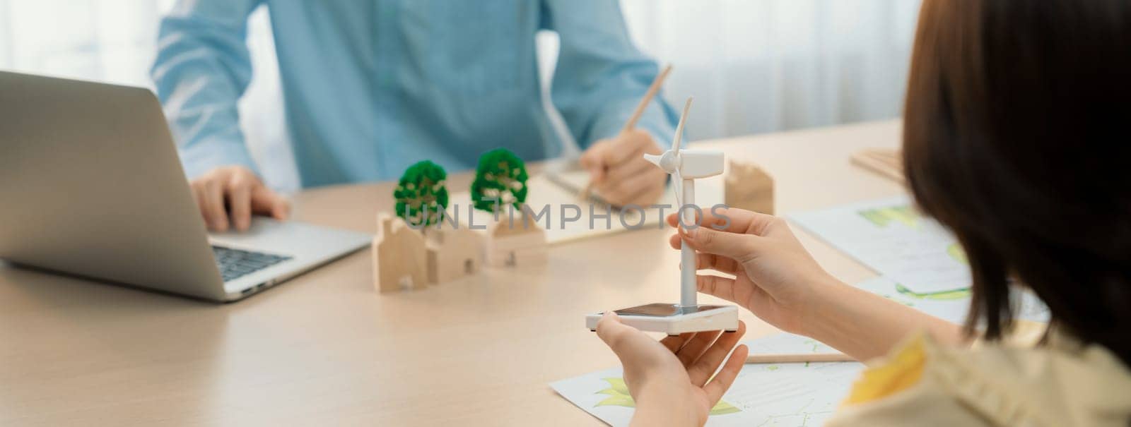 Businesswoman interested in investing in renewable energy at meeting table with environmental document scatter around. Business team discussion about green business project. Closeup. Delineation.