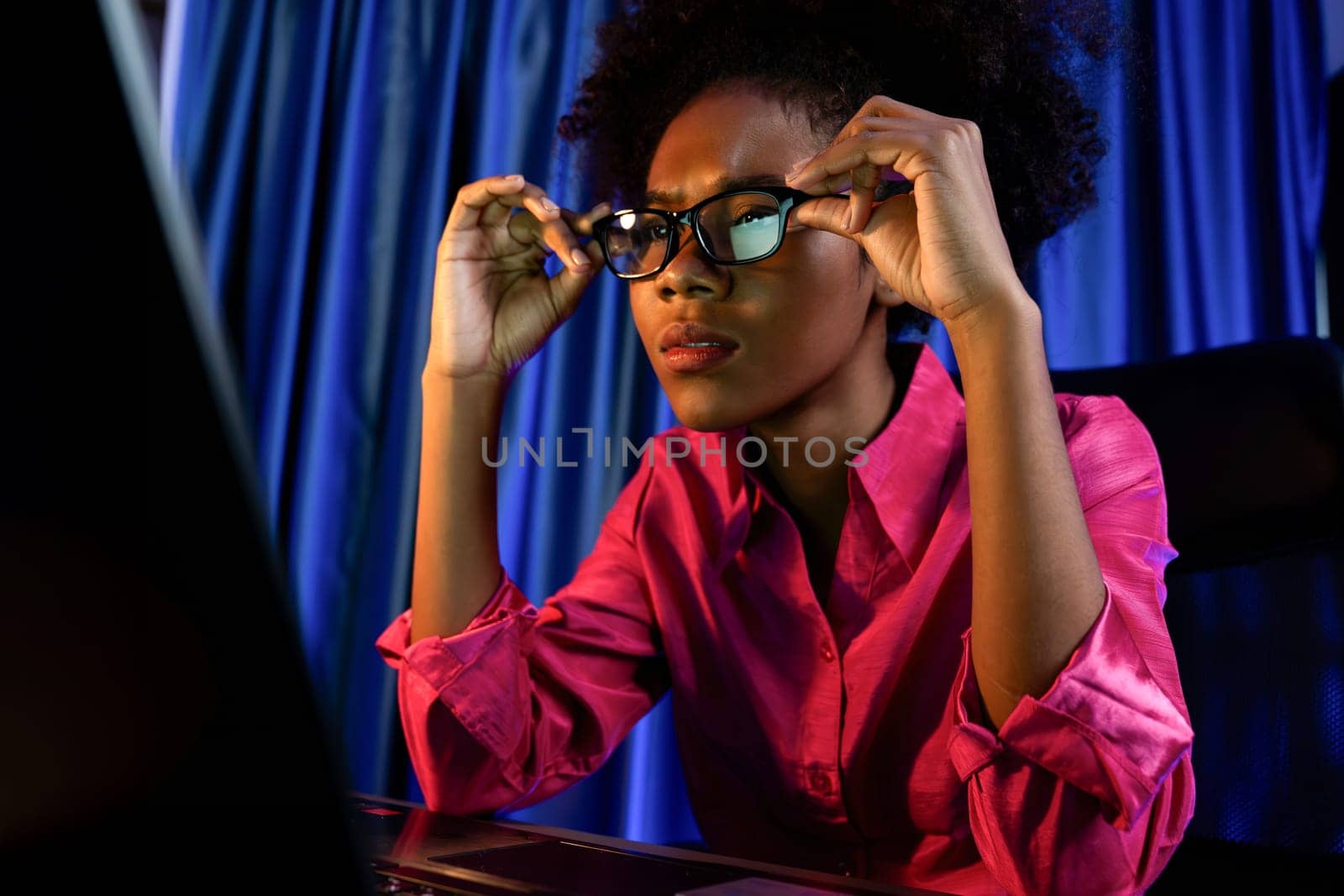 Working African woman blogger concentrated on the laptop screen with serious face, searching marketing data analysis, conclusion overall document on database for meeting report. Tastemaker.
