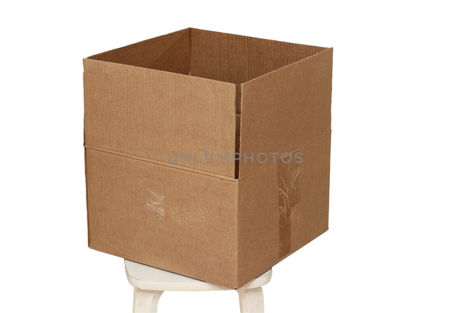 Rectangle cardboard box on beige stool for creative arts and toy storage.