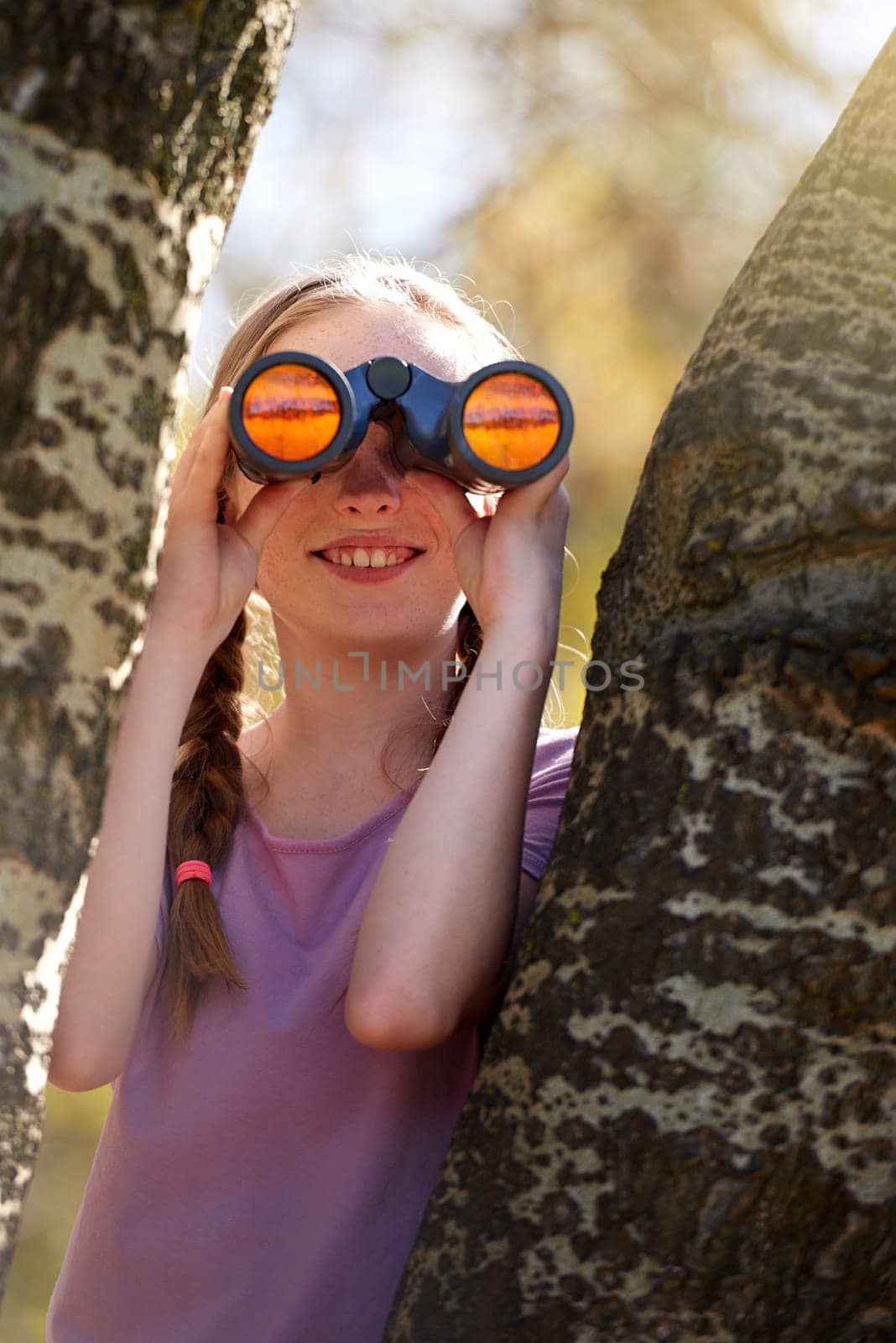 Tree, girl and binoculars for safari, search and looking for animals on travel holiday. Smile, fun and seek for bird watching or wildlife in nature, happy young child and scenery or view in Kenya.