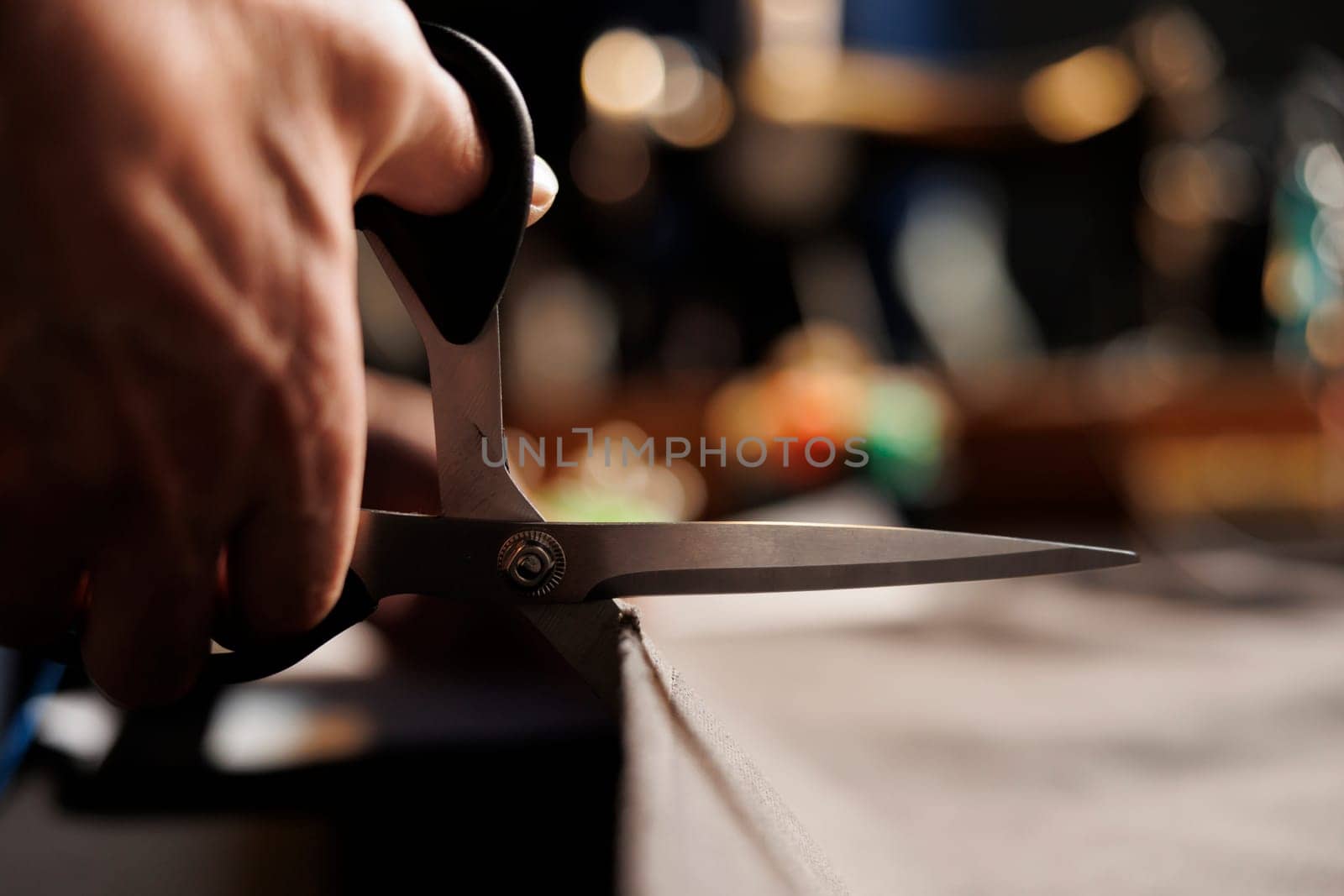 Close up of suitmaker cutting material by DCStudio