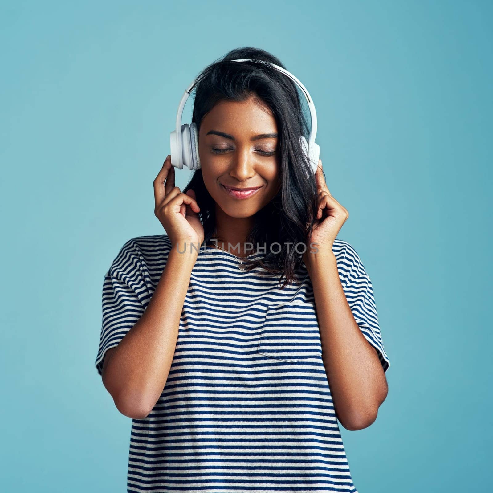 Woman, studio and headphones with happy music, listening and streaming podcast for calm with gen z. Radio audio, technology for song entertainment with sound, Indian female person on background by YuriArcurs