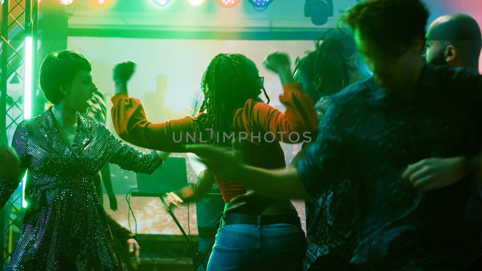 Persons having fun at dance party in nightclub by DCStudio