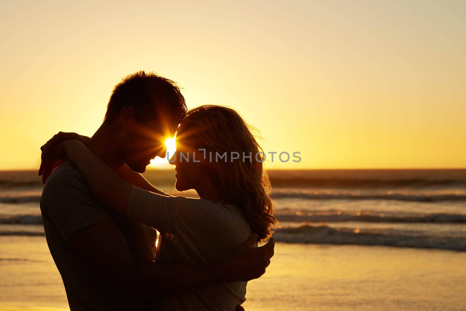 Couple, love and kiss at beach with sunset for date or summer holiday and bonding in Florida. Relationship, evening and romance together as soulmate with smile, vacation and happy with forehead touch.