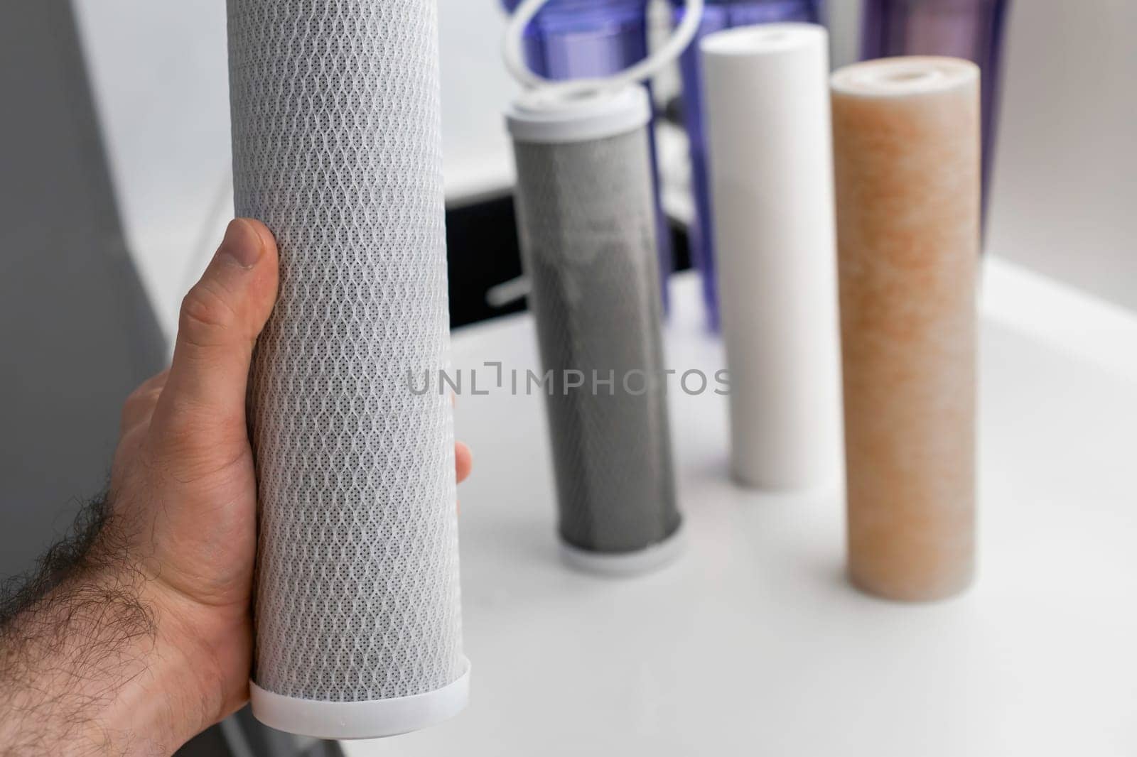 Man hands holding dirty filter for reverse osmosis for water purification on the table in the kitchen