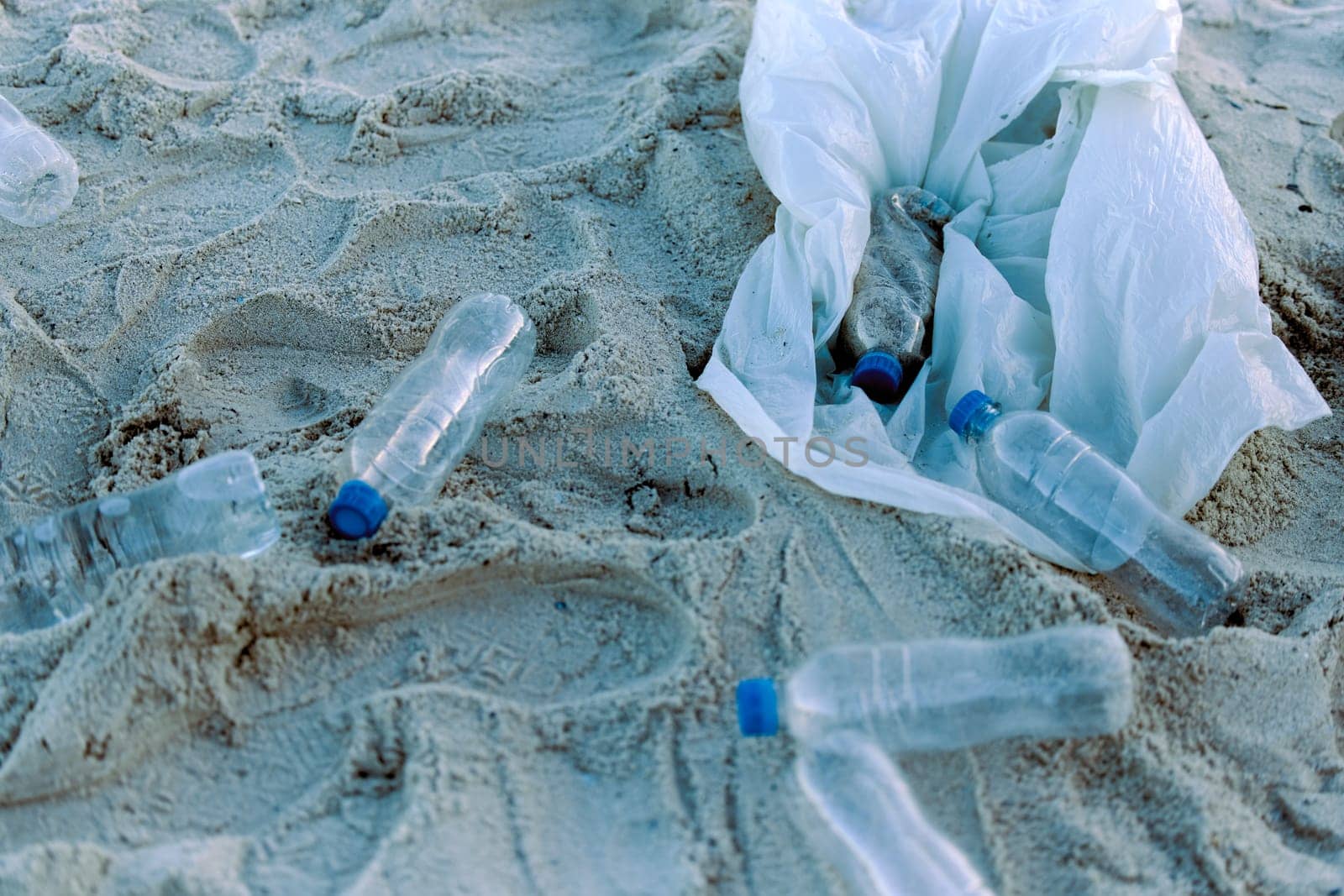 Plastic bottle, rubbish or recycling on sand pollution for clean up, waste management and environmental awareness. Garbage, trash or litter on beach for sustainability, eco friendly or conservation by YuriArcurs