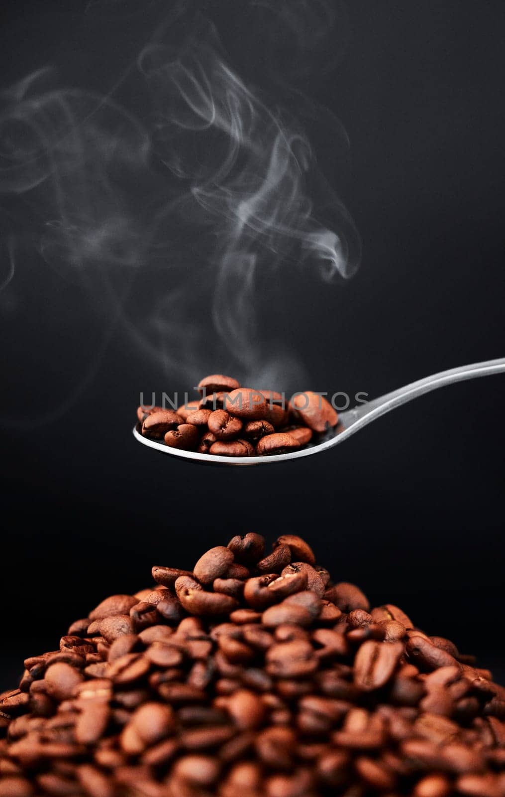 Studio, coffee beans and scent or aroma on spoon for organic diet, roast and black background. Art, seeds and texture of raw ingredient for espresso or flavor, cappuccino and steam on mockup space by YuriArcurs