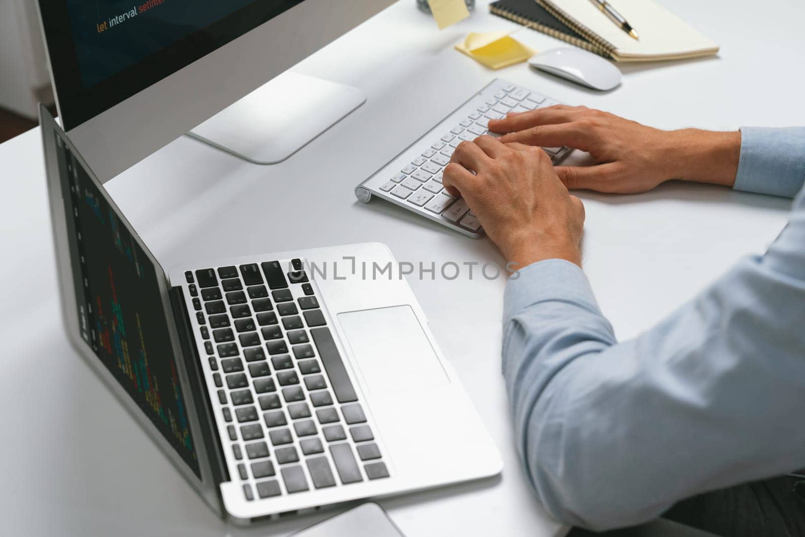 Cropped image of hands IT developer working online software information on pc and laptop with typing coding program on application project. Technical engineer writing crucial memo lists. Pecuniary.