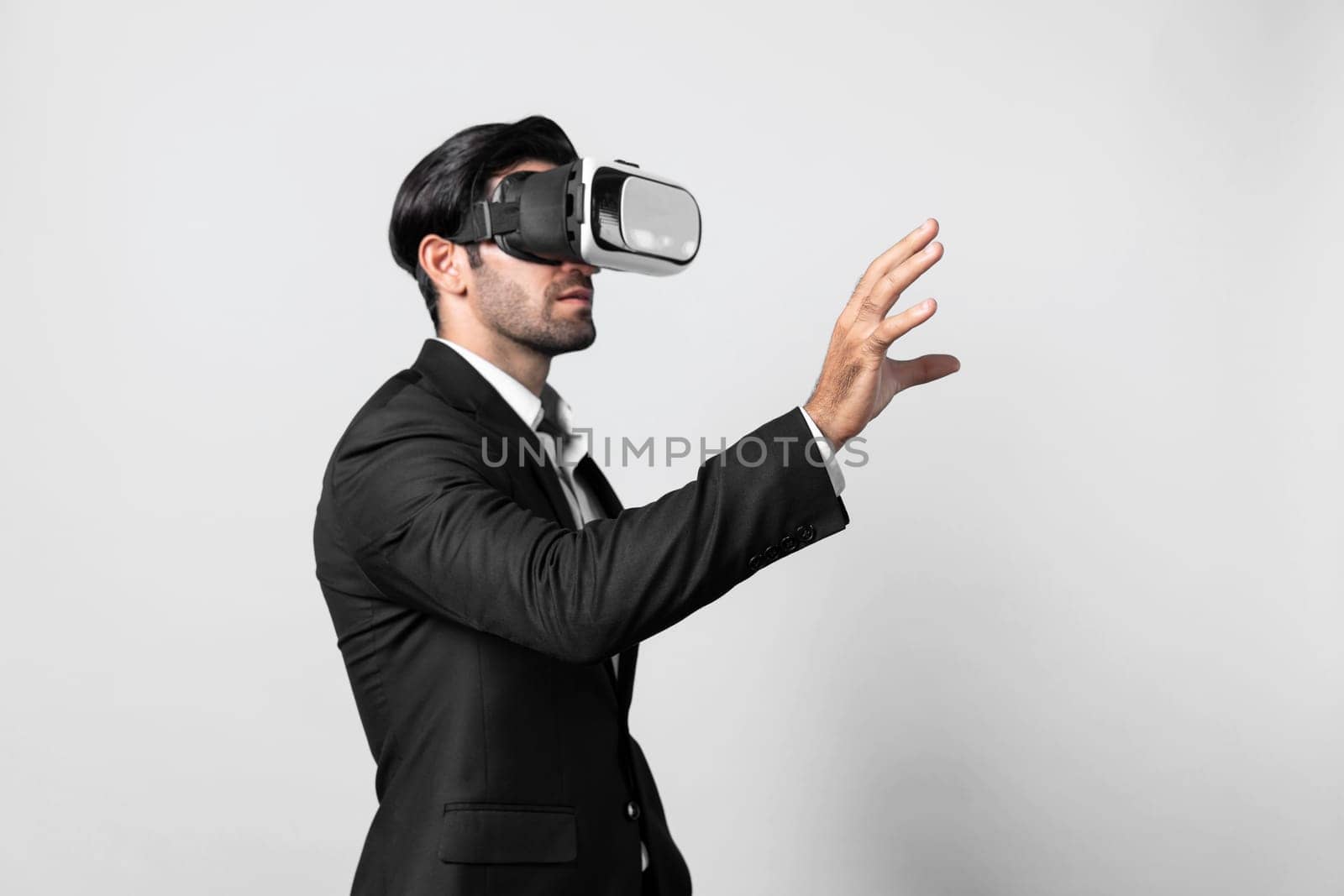 Professional smart business man holding something while wearing VR glasses. Caucasian project manager with virtual reality goggles while present technology innovation with blue background. Deviation.