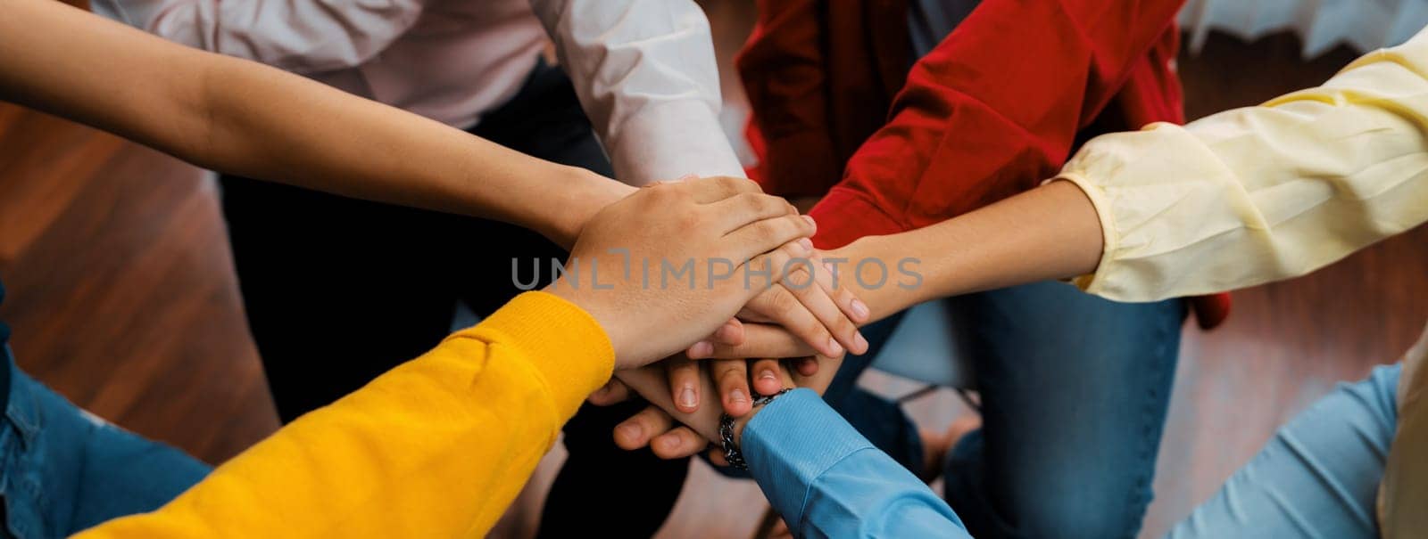 Startup company employee team stacking hand together symbolize successful group of business partnership and strong collective unity teamwork in community workplace in panoramic banner. Synergic