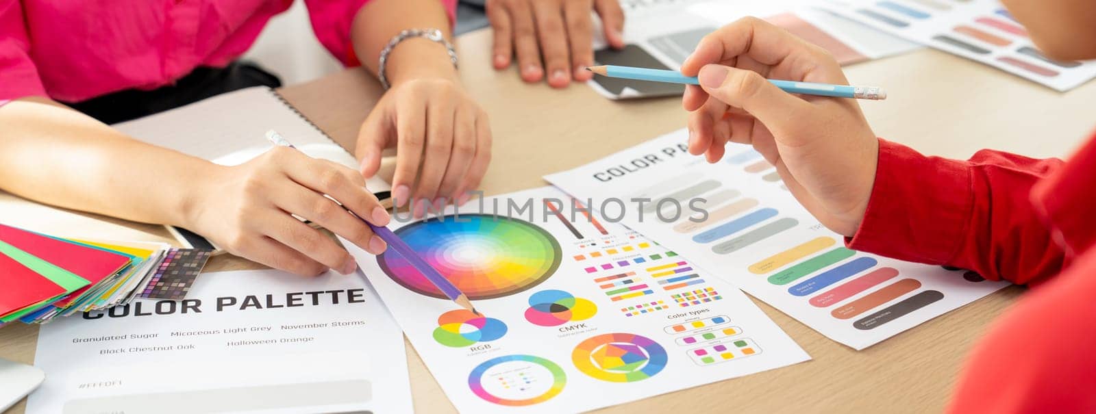 Creative interior designer brainstorming about color of material. Group of architect designer choose color carefully by using color swatches. Creative design and teamwork concept. Variegated.