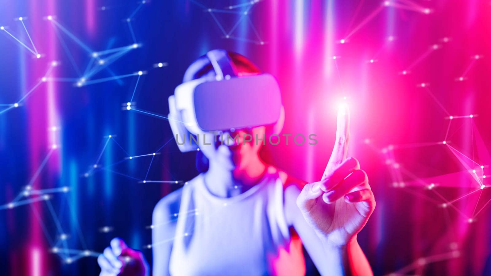 Smart female standing surrounded by neon light wearing VR headset connecting metaverse, future cyberspace community technology. Elegant woman using her finger touching virtual object. Hallucination.
