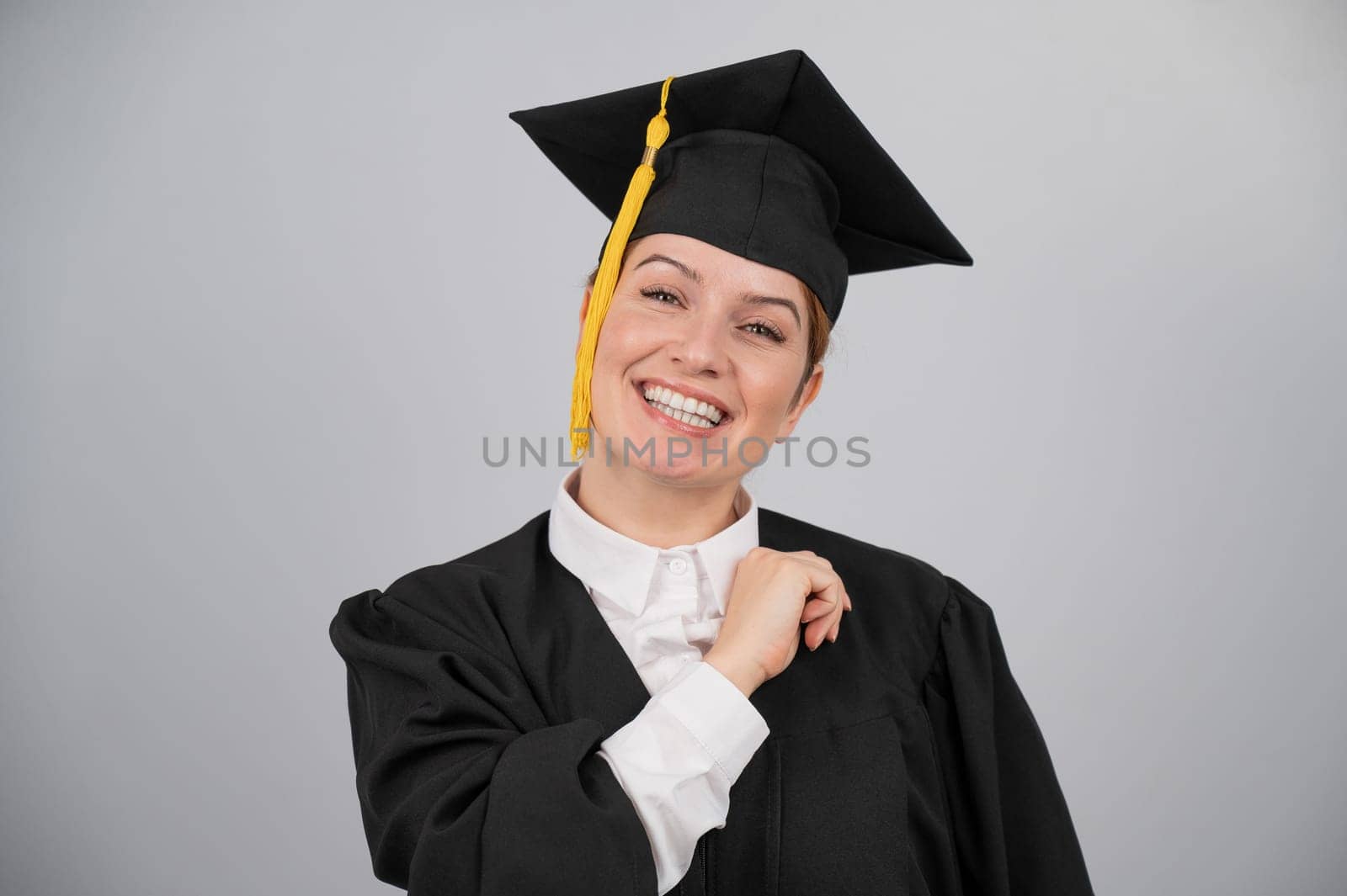 Smiling woman in graduation gown on white background. by mrwed54