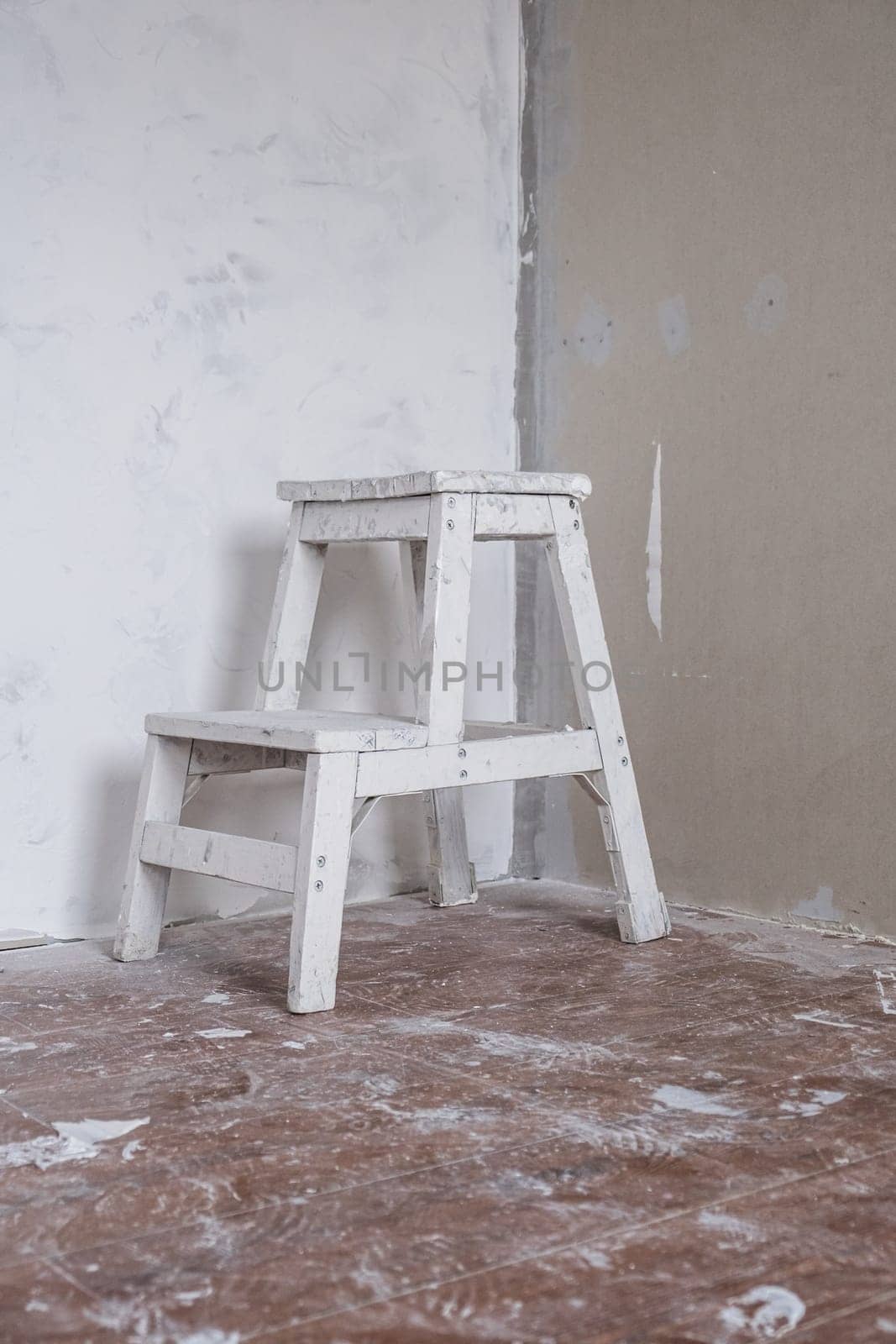 Applying decorative putty. A white repair chair. White abstract texture of surface covered with putty. textured background of filler paste applied with putty knife in irregular dashes and strokes.