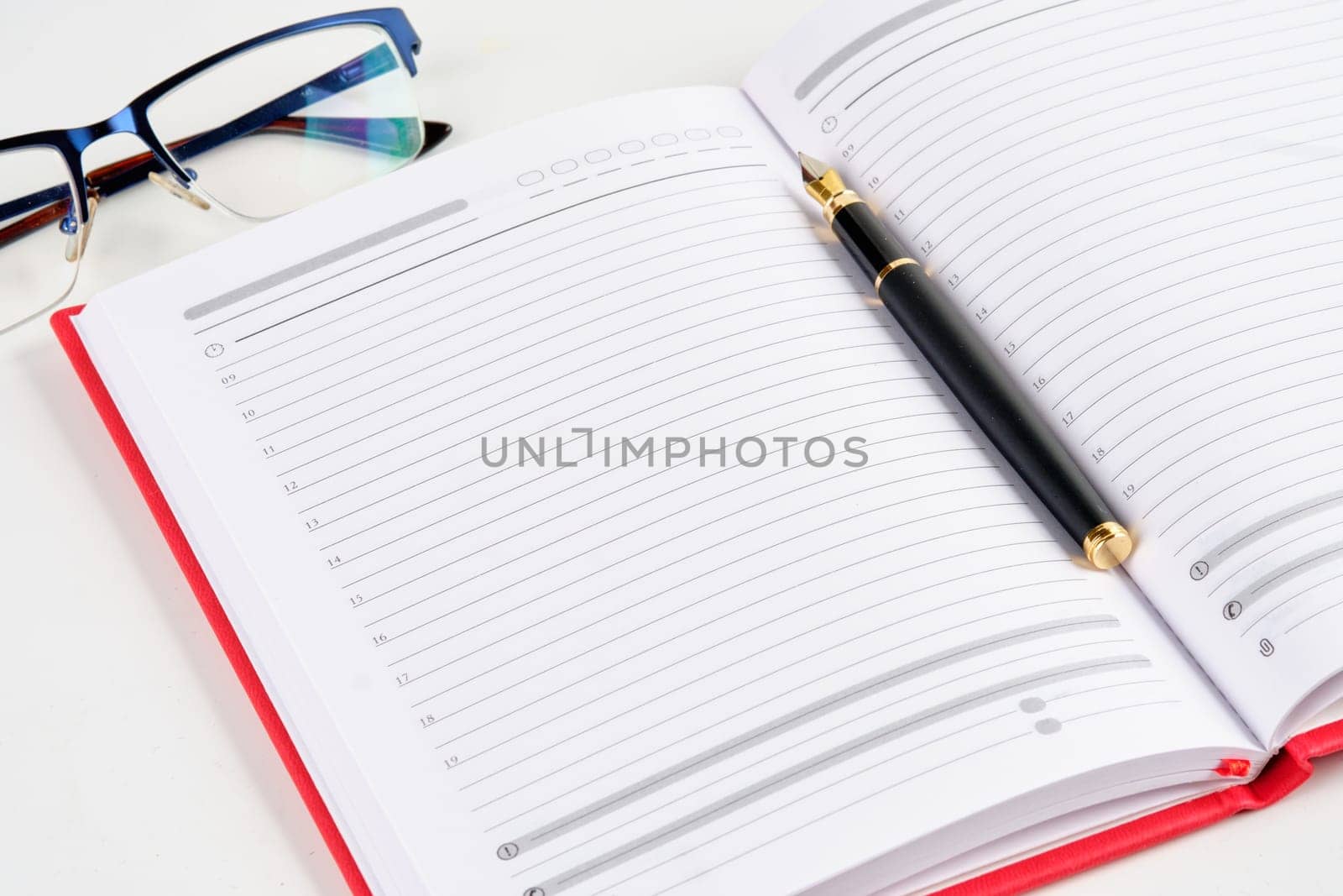 A photo of a notebook of glasses and a black fountain pen with a place for space. The concept of business and training