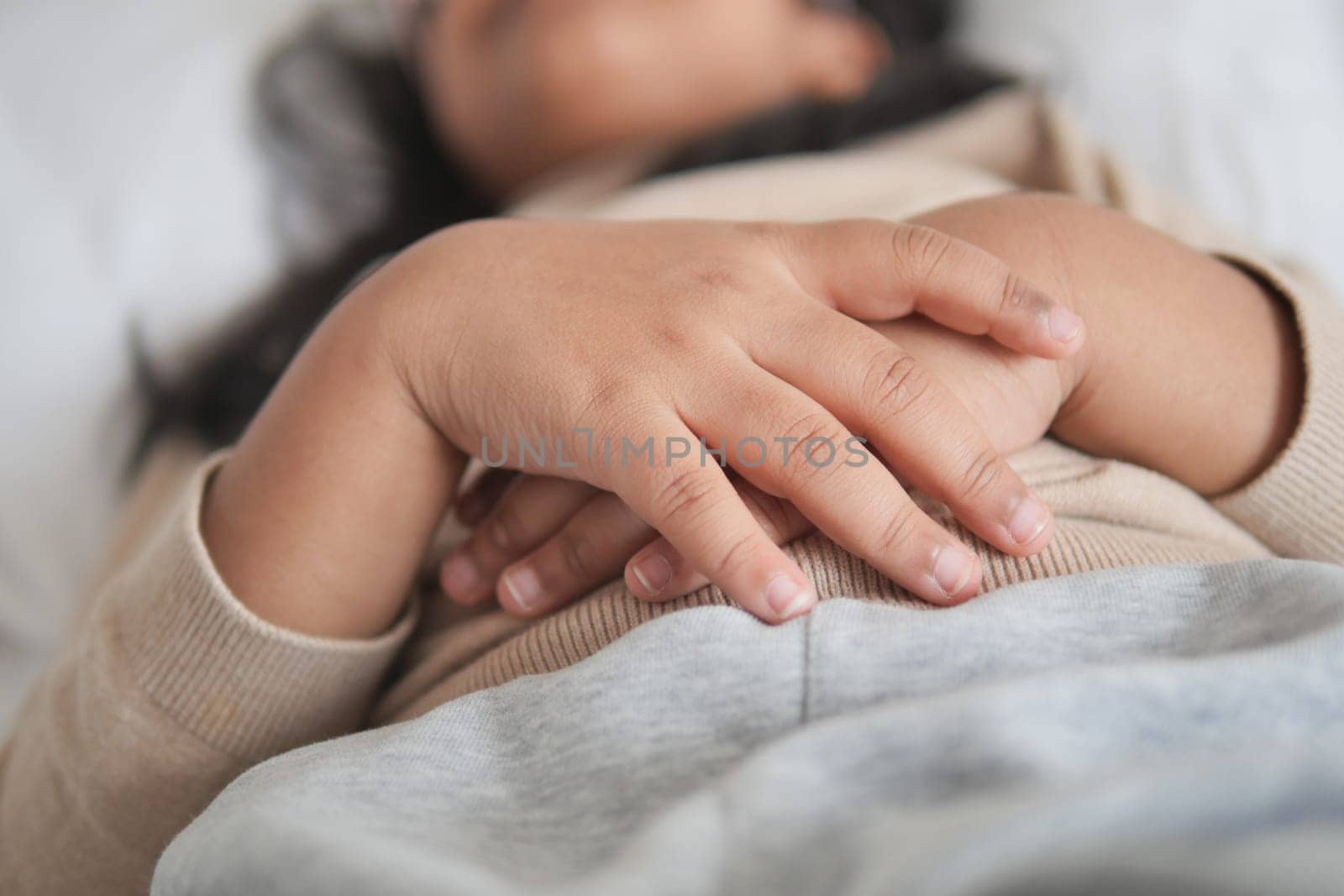 a child sleeping on bed .