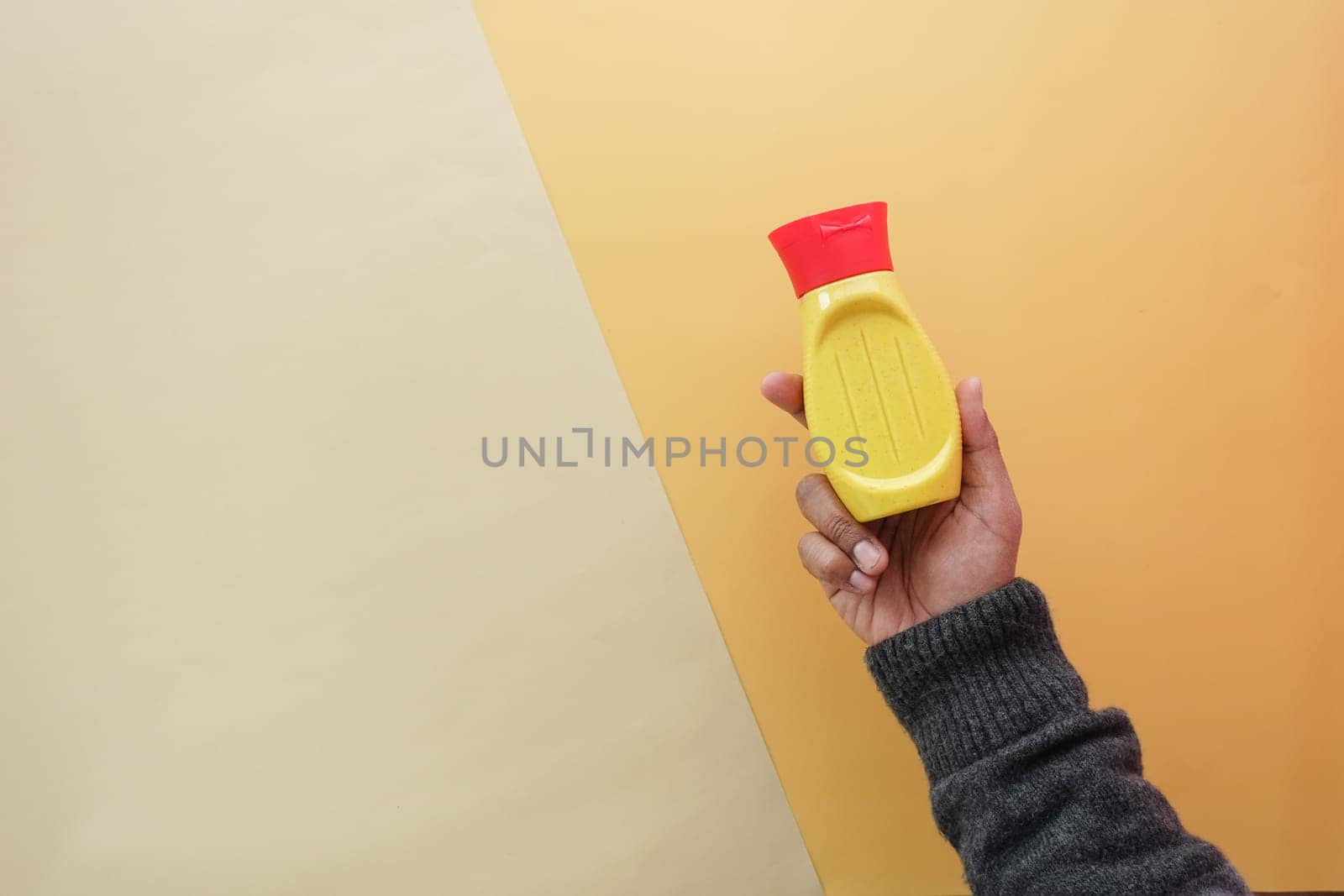 top view of holding a mustard mayonnaise container .