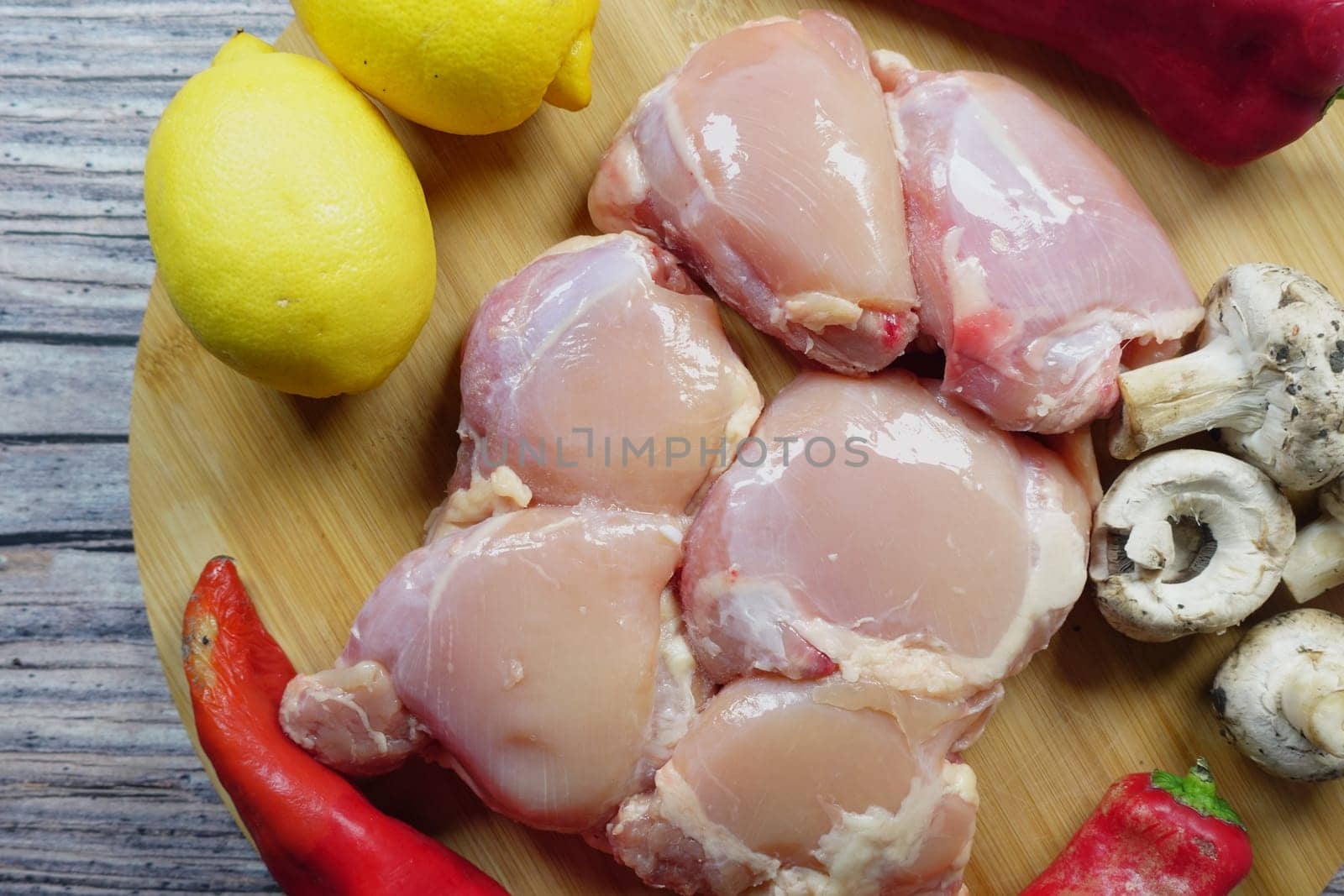 raw breast chicken meat and vegetables on a chopping board by towfiq007