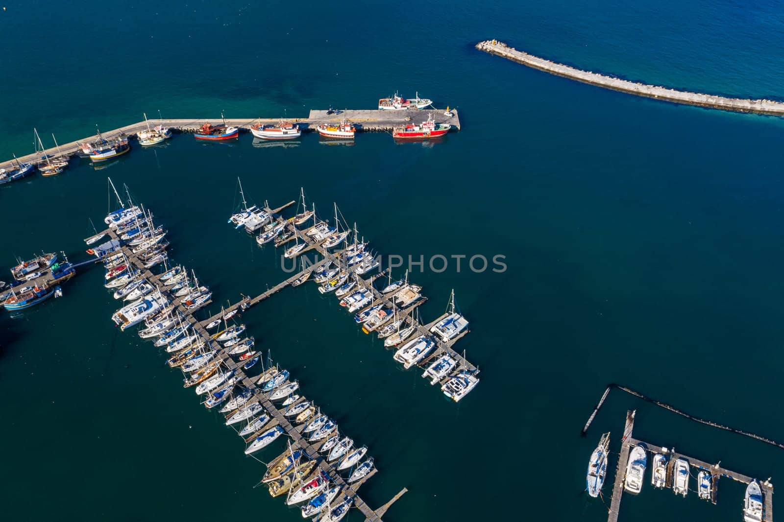 Aerial drone, boats and harbour with ocean, port and marina for travel or cruise holiday. Top view, dock and sea with sailboat, nautical pier or jetty with water scenery and panorama background.