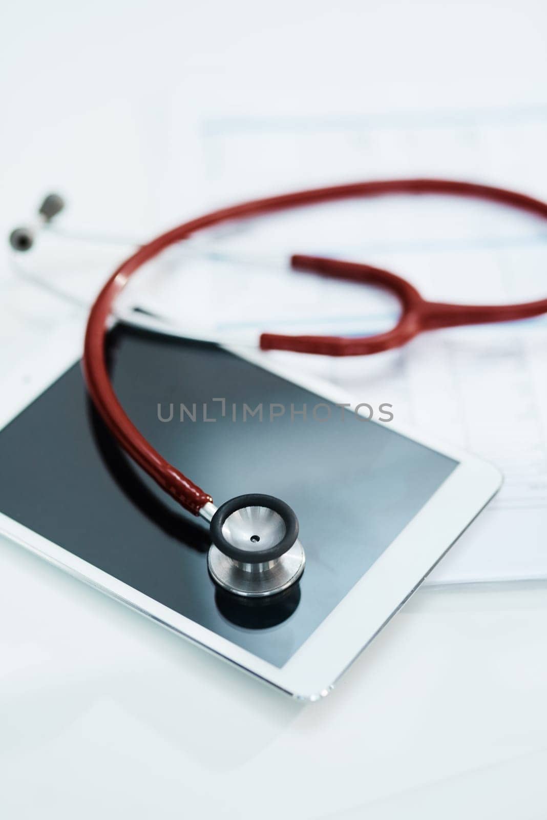 Hospital, telehealth and tablet with stethoscope on desk for medical website, healthcare and research. Documents, cardiology and digital tech, equipment and clipboard for online consulting service.