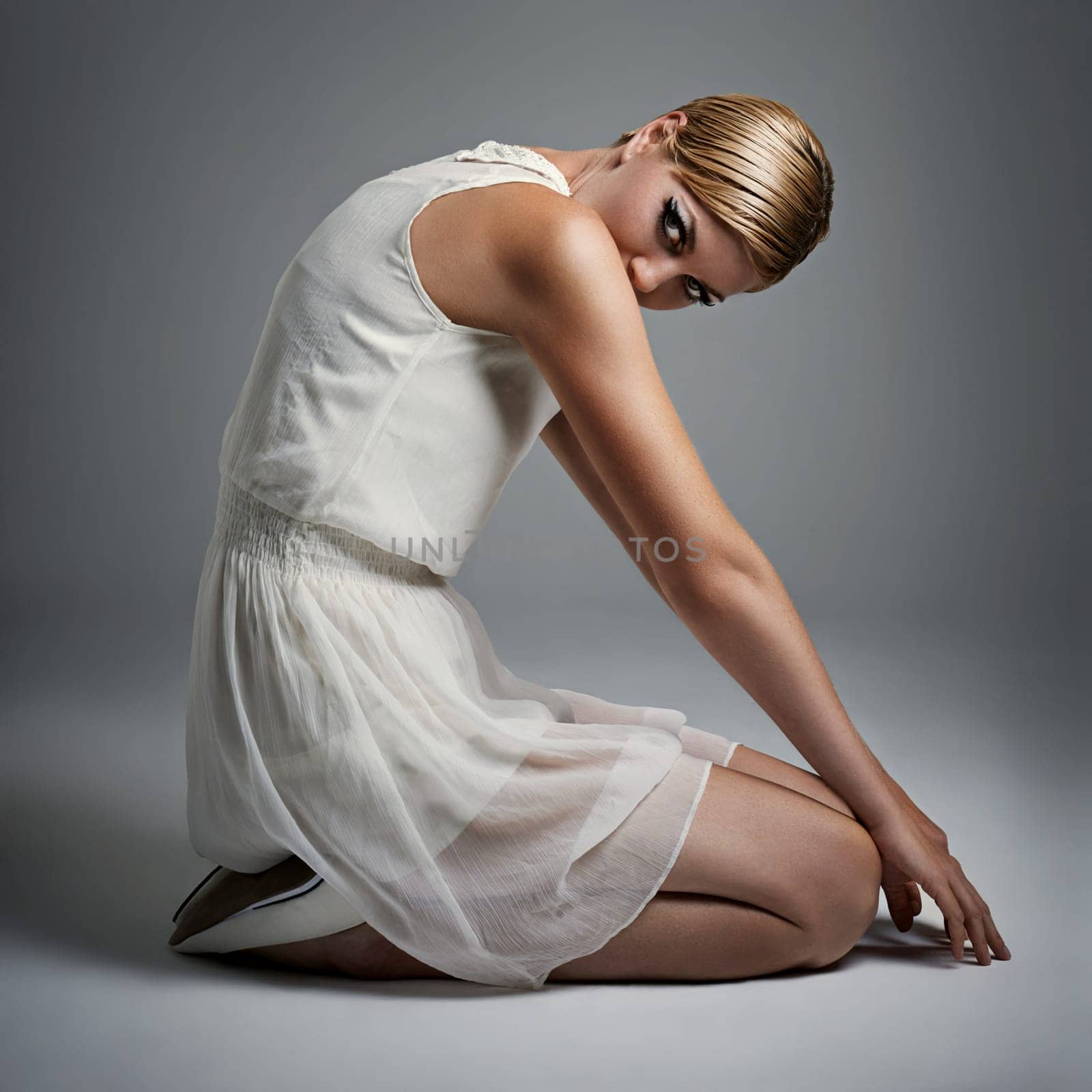 Portrait, woman and ballet in dress at studio on isolated white background, kneeling and makeup for performance. Female person, dancer and performer or artist with practice for concert with fashion by YuriArcurs