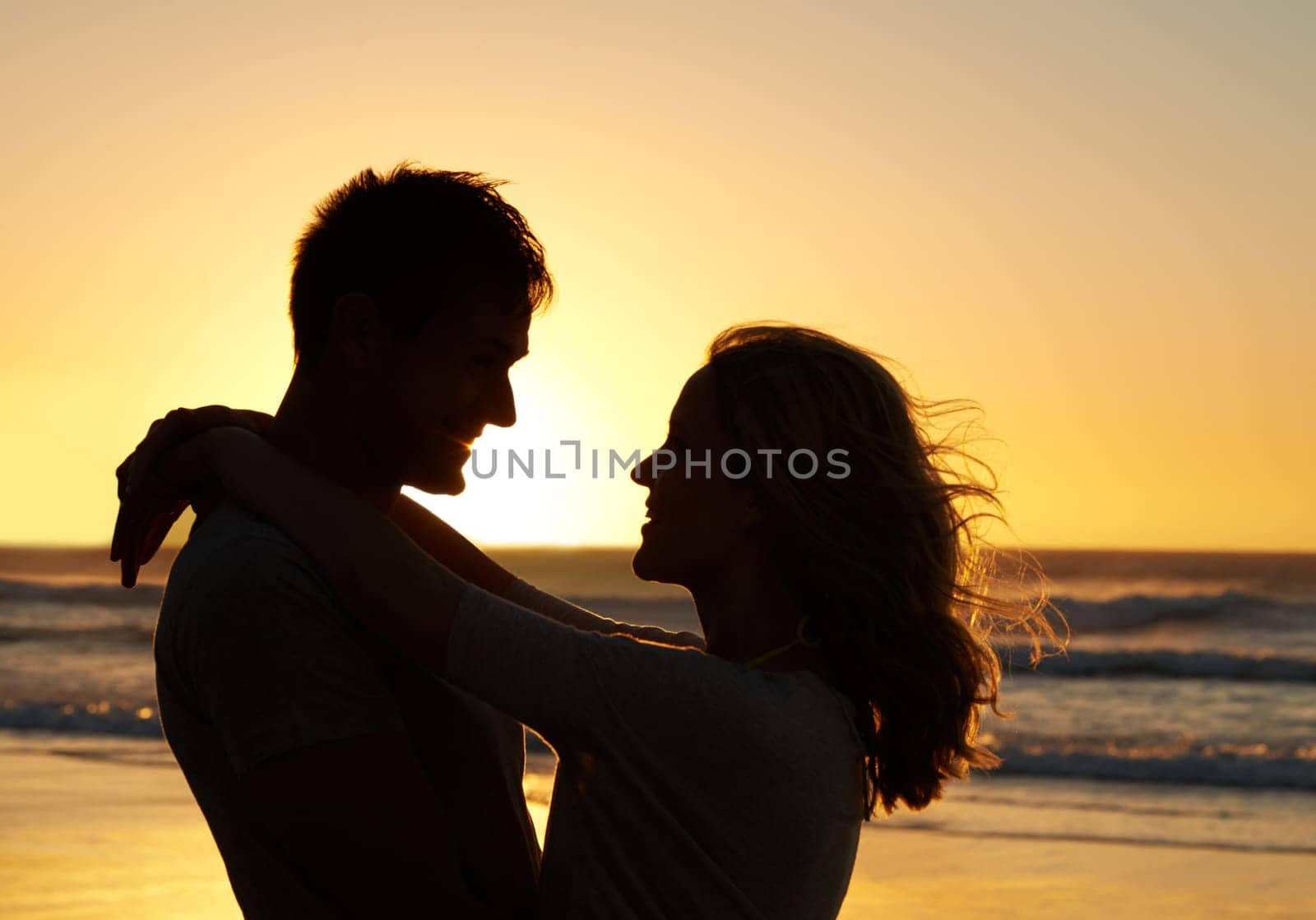 Couple, love and smile at beach with sunset for date or summer holiday and bonding in Florida. Relationship, silhouette and romance together as soulmate with travel, hug and vacation for honeymoon.