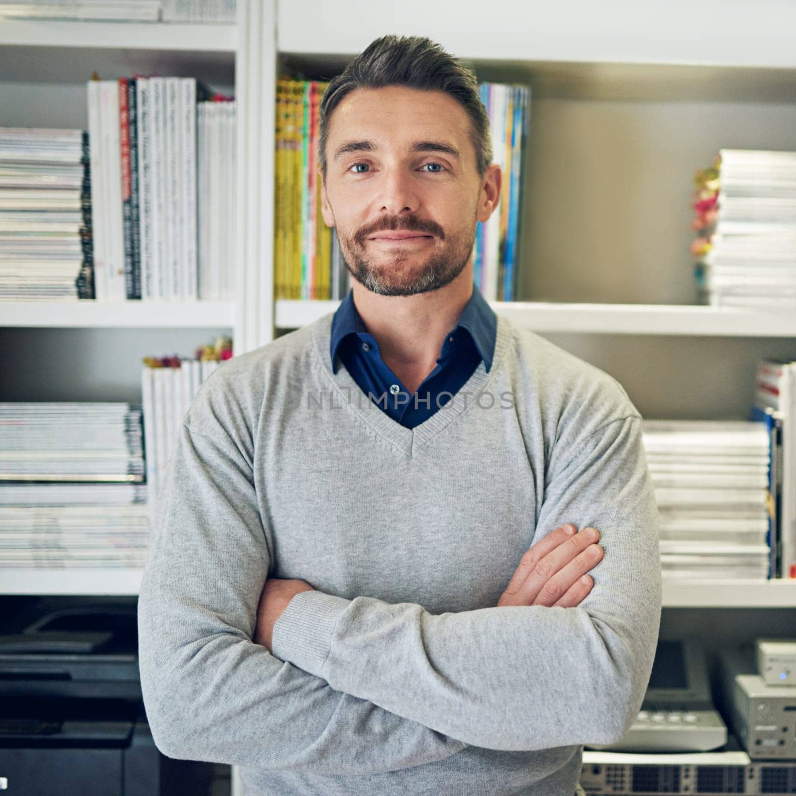 Businessman, portrait and crossed arms in office, smile and happy teacher with bookshelf and books for information. Educational development, lecturer for university professor or advisor for teaching.