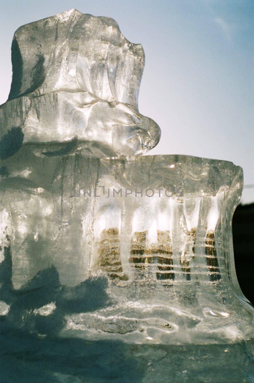 Block of ice translucent sculpture against the sky. by gelog67