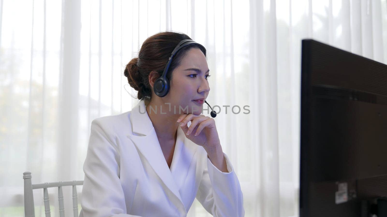 Businesswoman wearing headset working in office to support remote customer or colleague. Frustrated and tired call center customer support agent facing problem on providing vivancy service