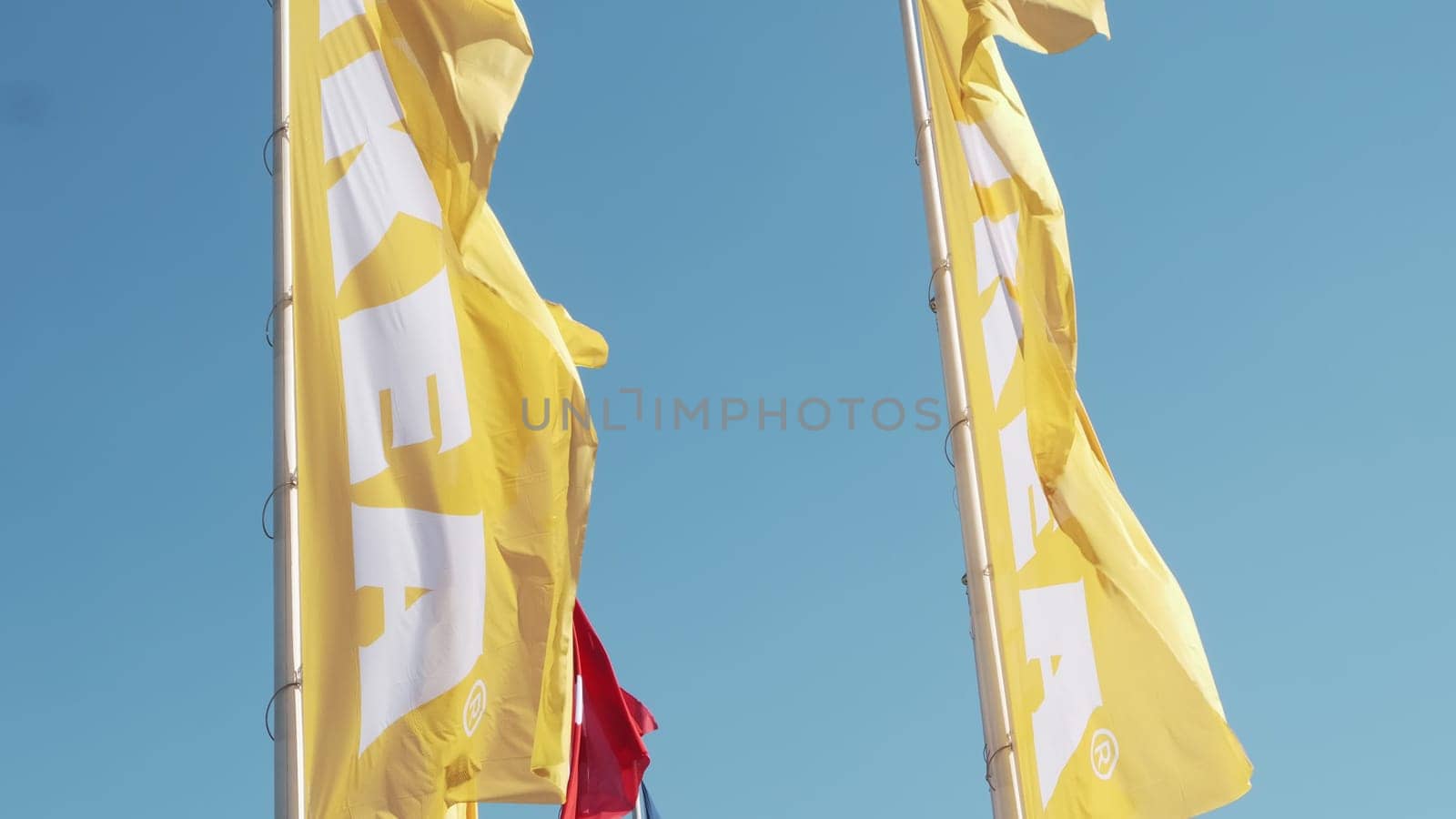 PRAGUE, CZECHIA -APRIL, 2024: Yellow and red IKEA flags waving in the wind against sky.