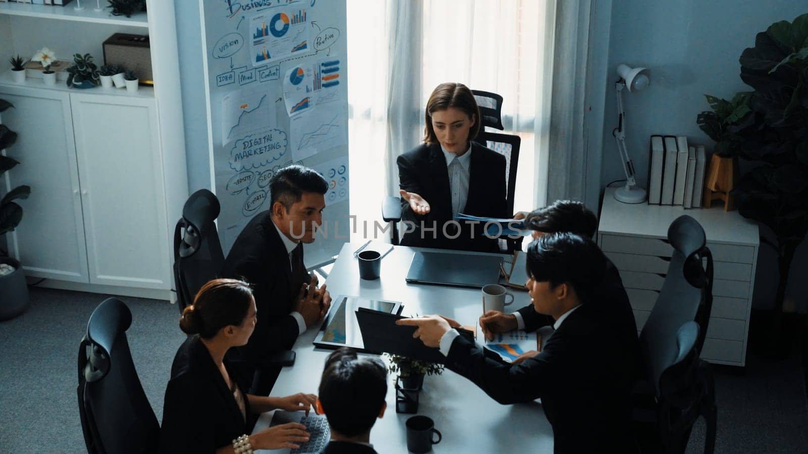 Top view of professional executive manager show increasing sales chart to diverse team while group of diverse business people listening and clapping hands to celebrate successful project. Directorate.