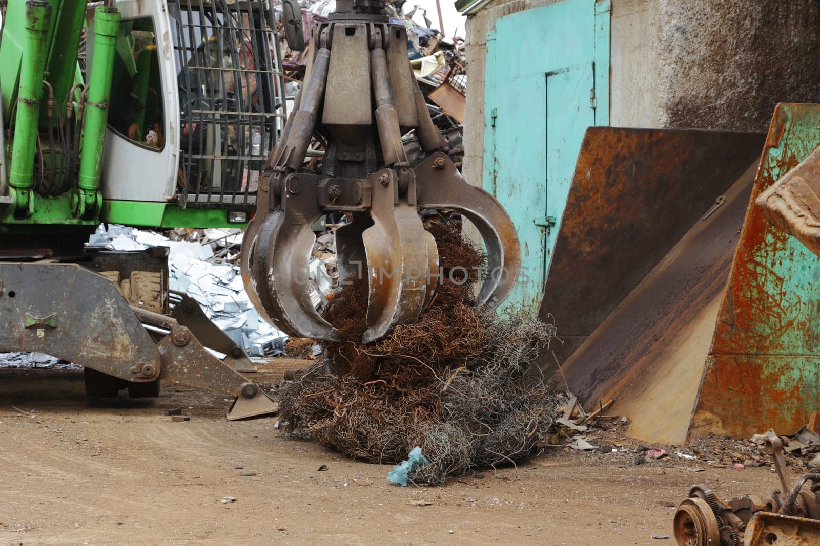 Jaw crane picking up scrap metal for loading. by gelog67