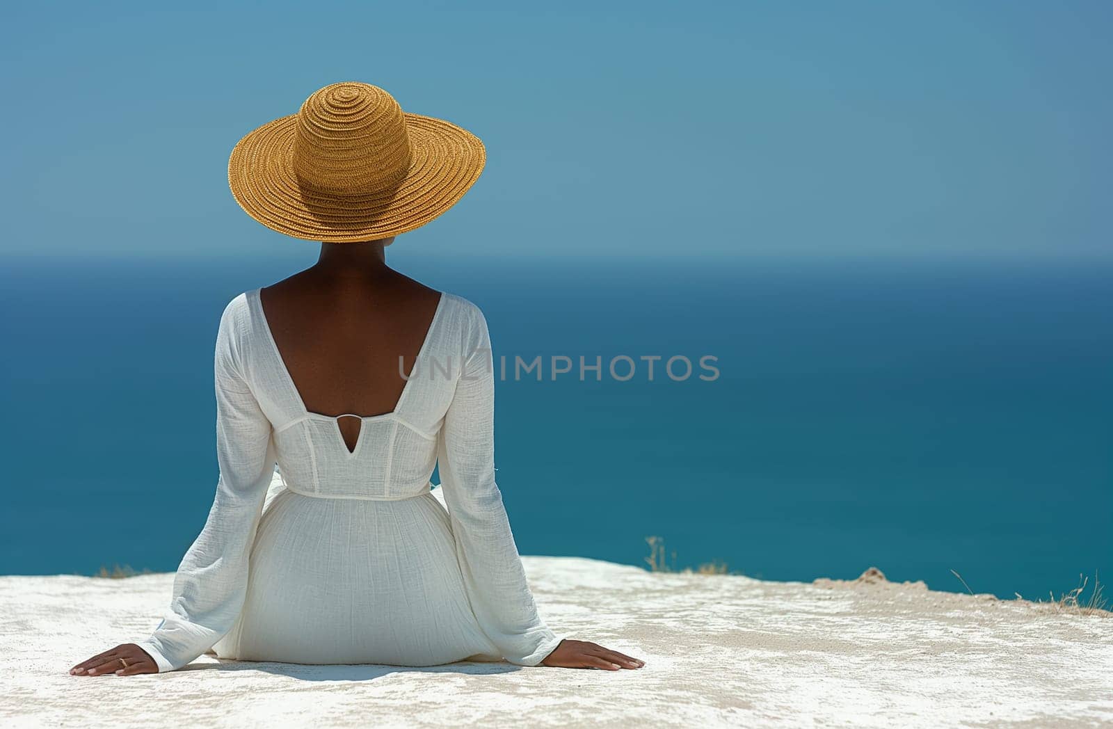 Black woman sitting by the sea, dressed in white, looking at a horizon with deep blue water. by Hype2art