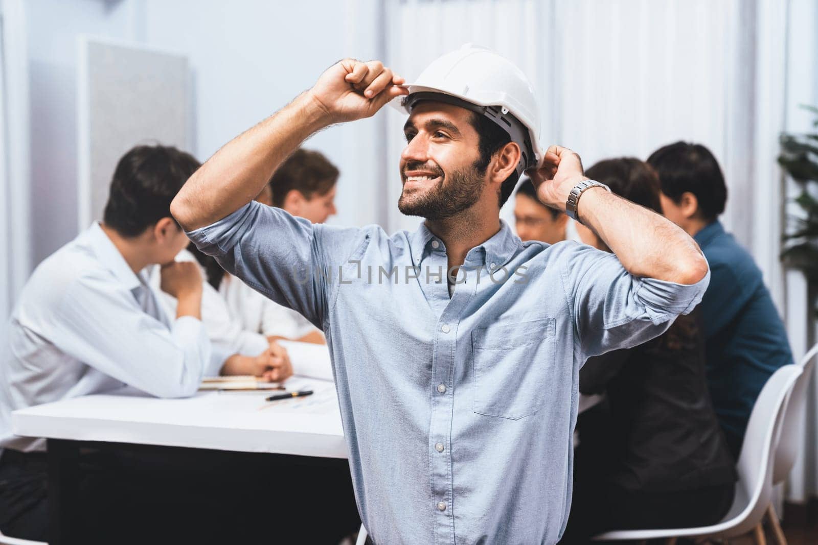 Engineer team leader portrait with diverse group of civil engineer and client working together on architectural project, reviewing construction plan and building blueprint at meeting table. Prudent