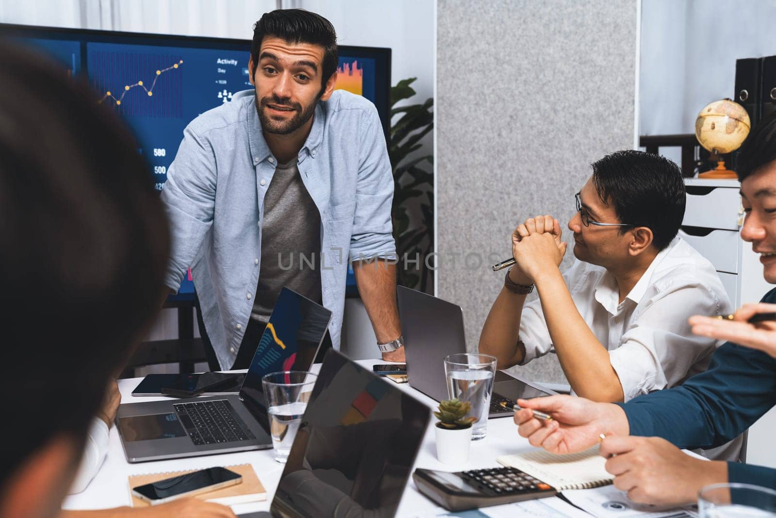 Analyst team utilizing BI Fintech to analyze financial data at table in meeting room. Businesspeople analyzing BI dashboard power for business insight and strategic marketing planning. Prudent