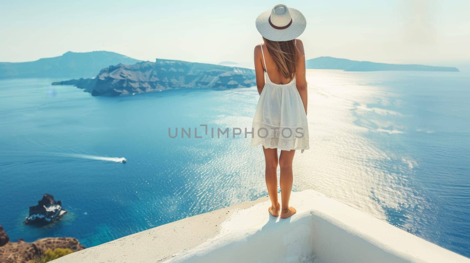 A woman in a white dress standing on top of the ledge overlooking water