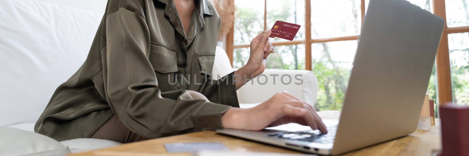 Young happy Asian woman buy product by online shopping at home while ordering items from the internet with credit card online payment protected by uttermost cyber security from online store platform