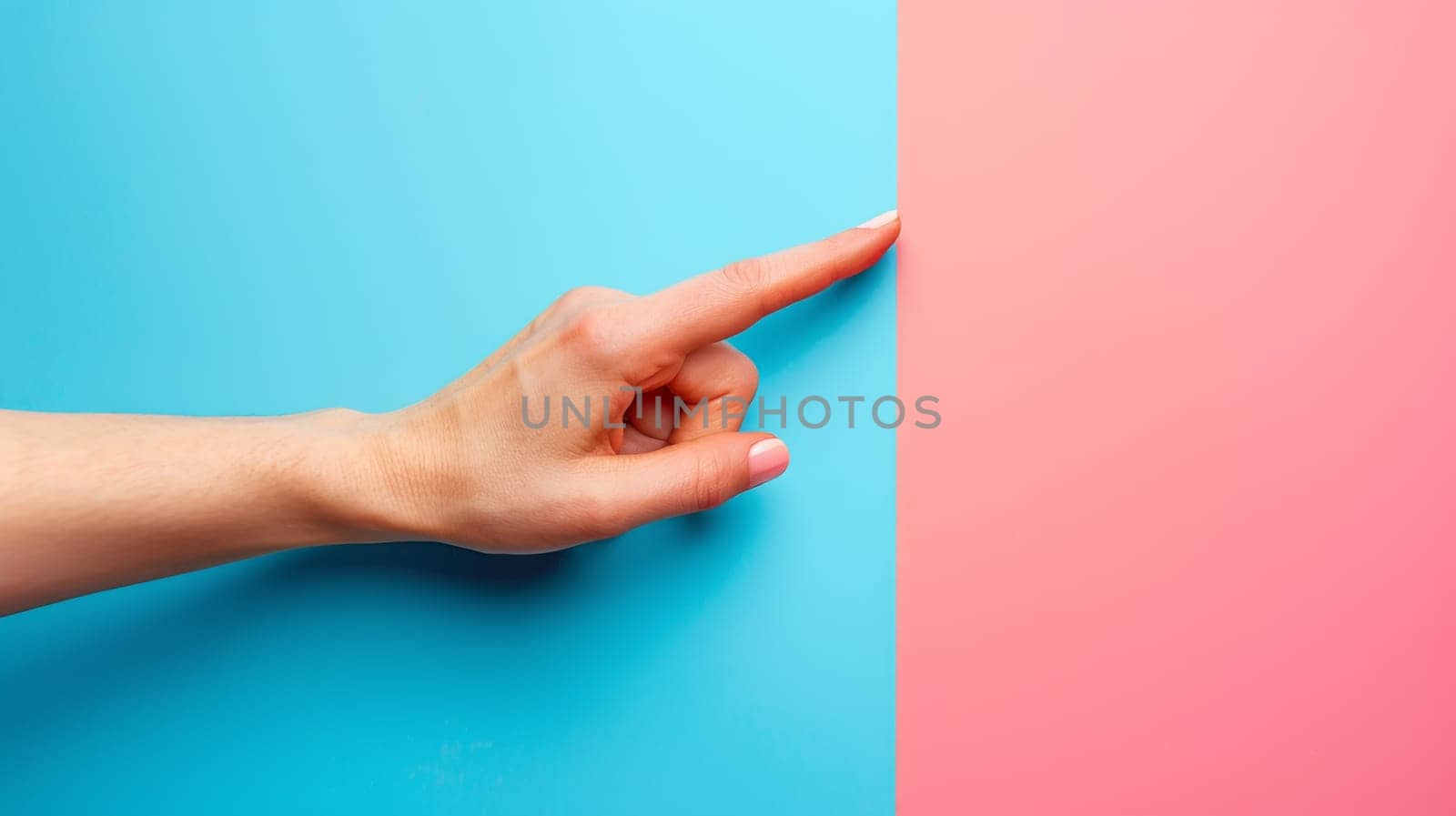 A hand pointing at a pink and blue wall with the finger