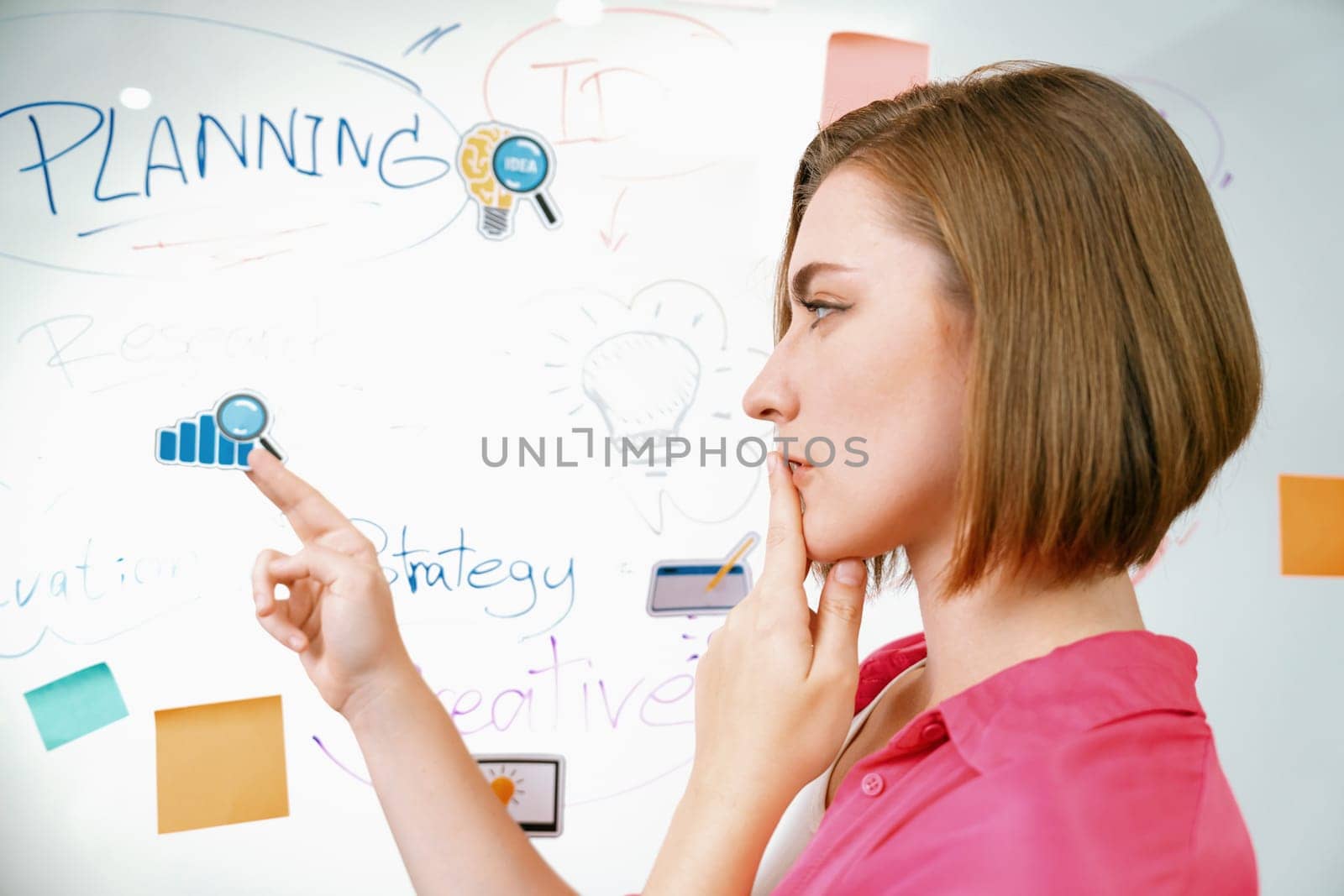 Portrait of young beautiful caucasian businesswoman thinking creative marketing strategy idea in front of whiteboard with mind map and colorful sticky notes. Arm chin. Closeup. Immaculate.