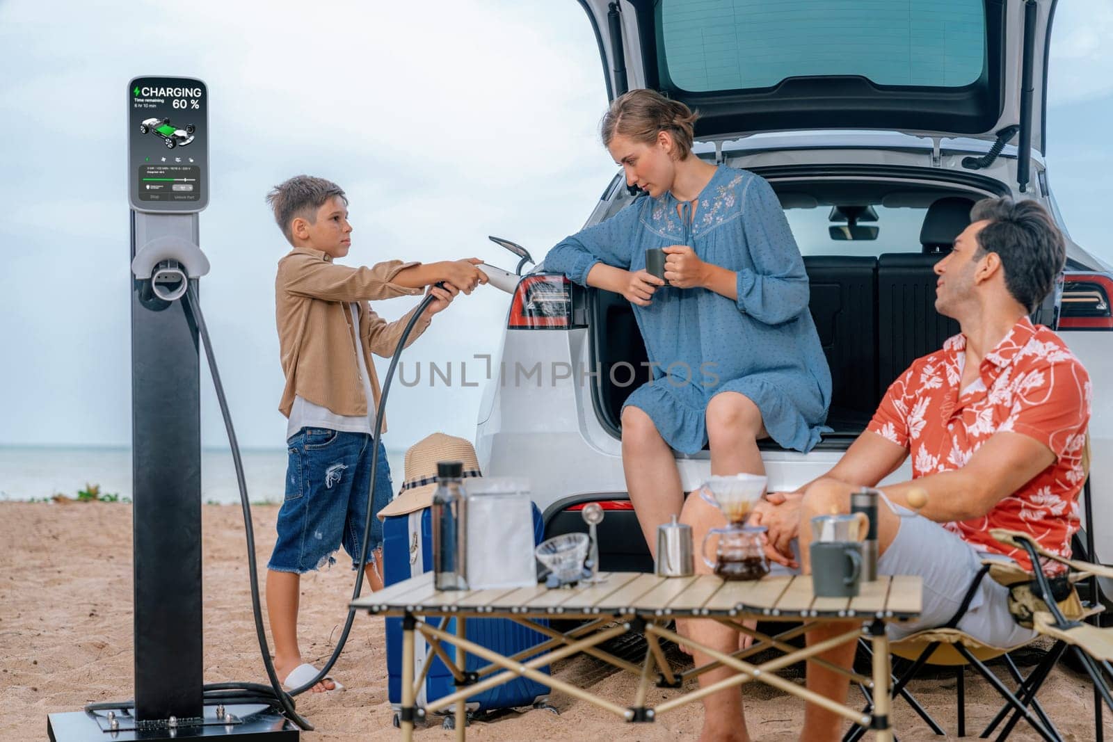 Family vacation trip traveling by the beach with electric car, happy family recharge EV car, enjoying outdoor camping coffee. Seascape travel and eco-friendly car for clean environment. Perpetual