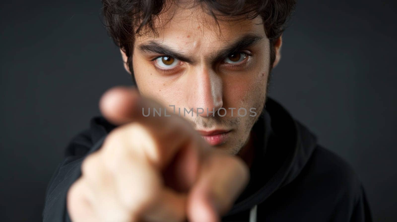 A man pointing a finger at the camera with his other hand