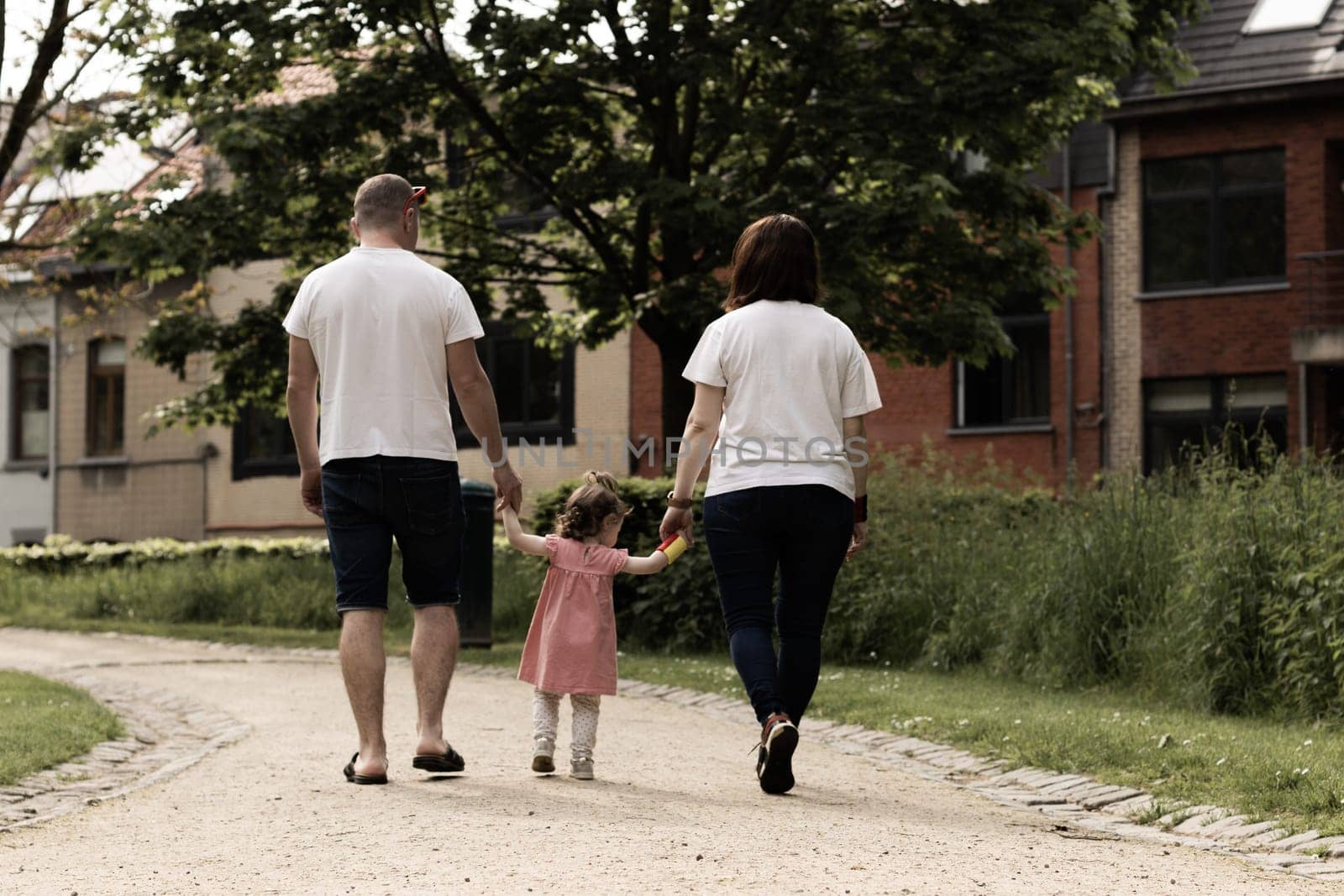 Portrait of a beautiful caucasian family walking in the park. by Nataliya