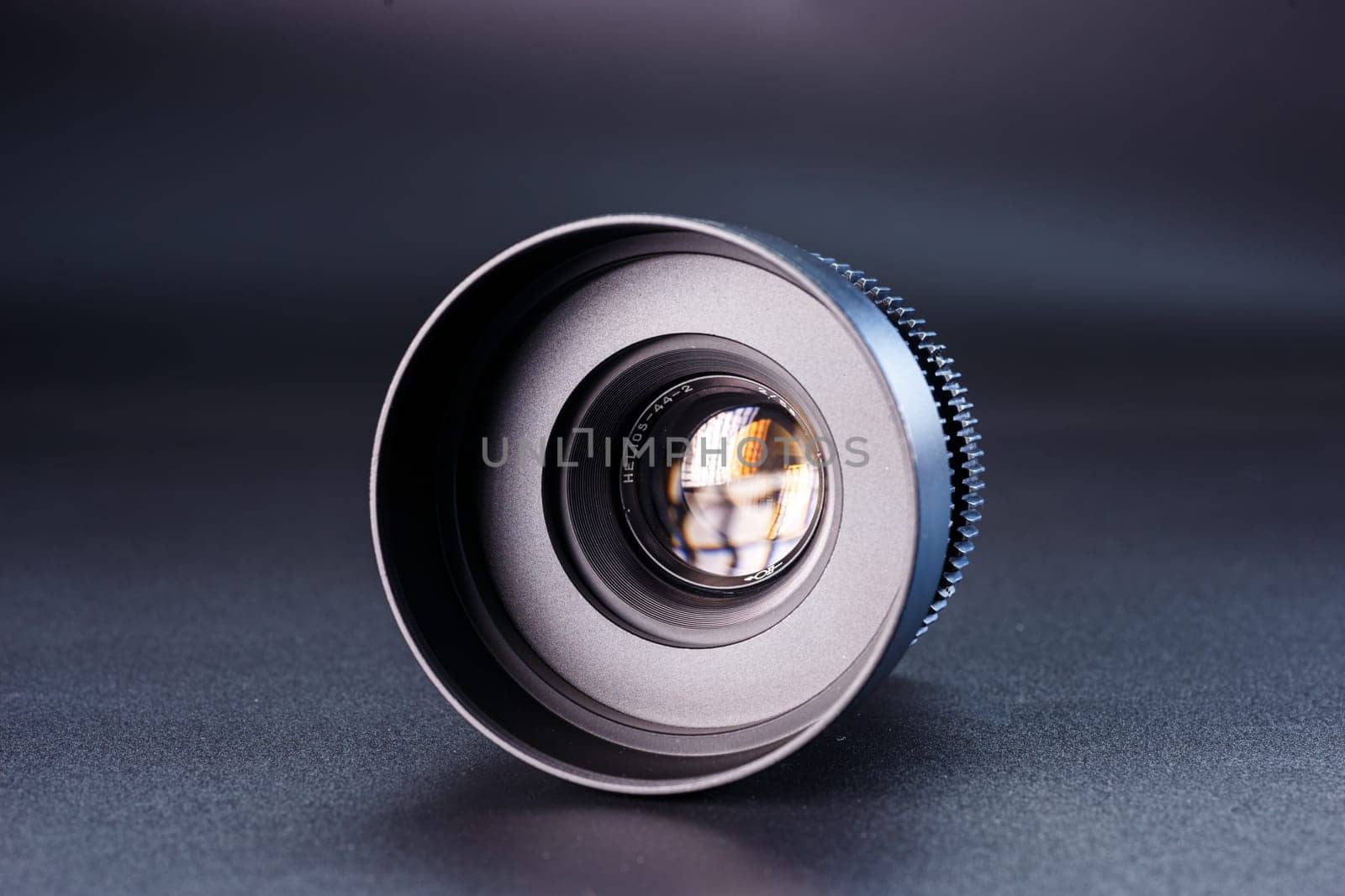 Close-up view of vintage Helios camera lens, black finish, photography gear on dark background, detailed focus rings visible, professional photographic equipment by mosfet_ua