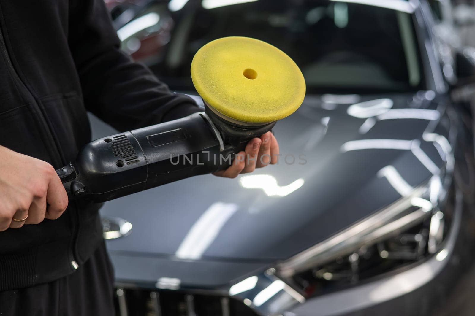 A master holds a device for polishing the surface of a car body. by mrwed54